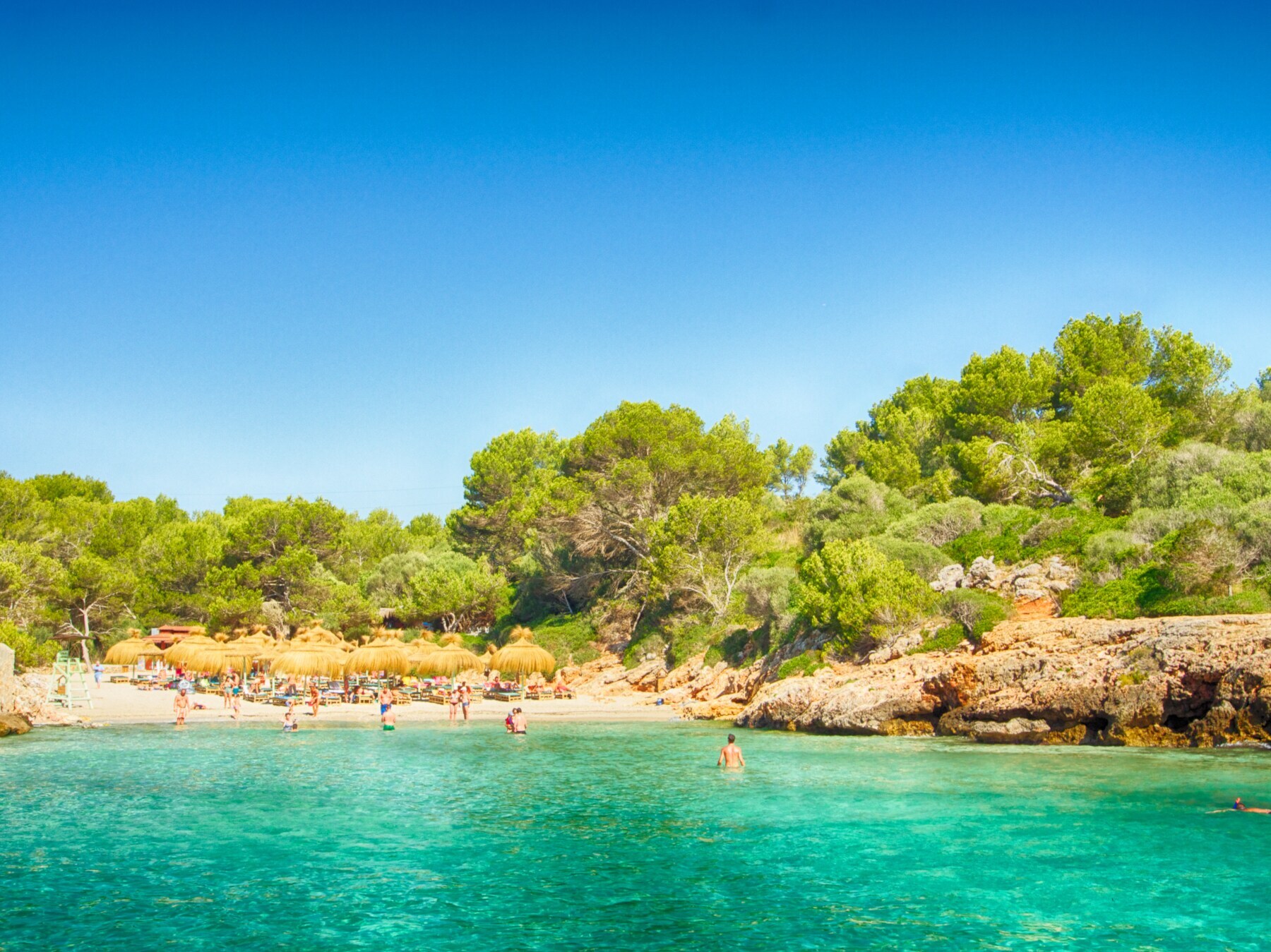 Menschen an der Bucht Cala Sa Nau auf Mallorca