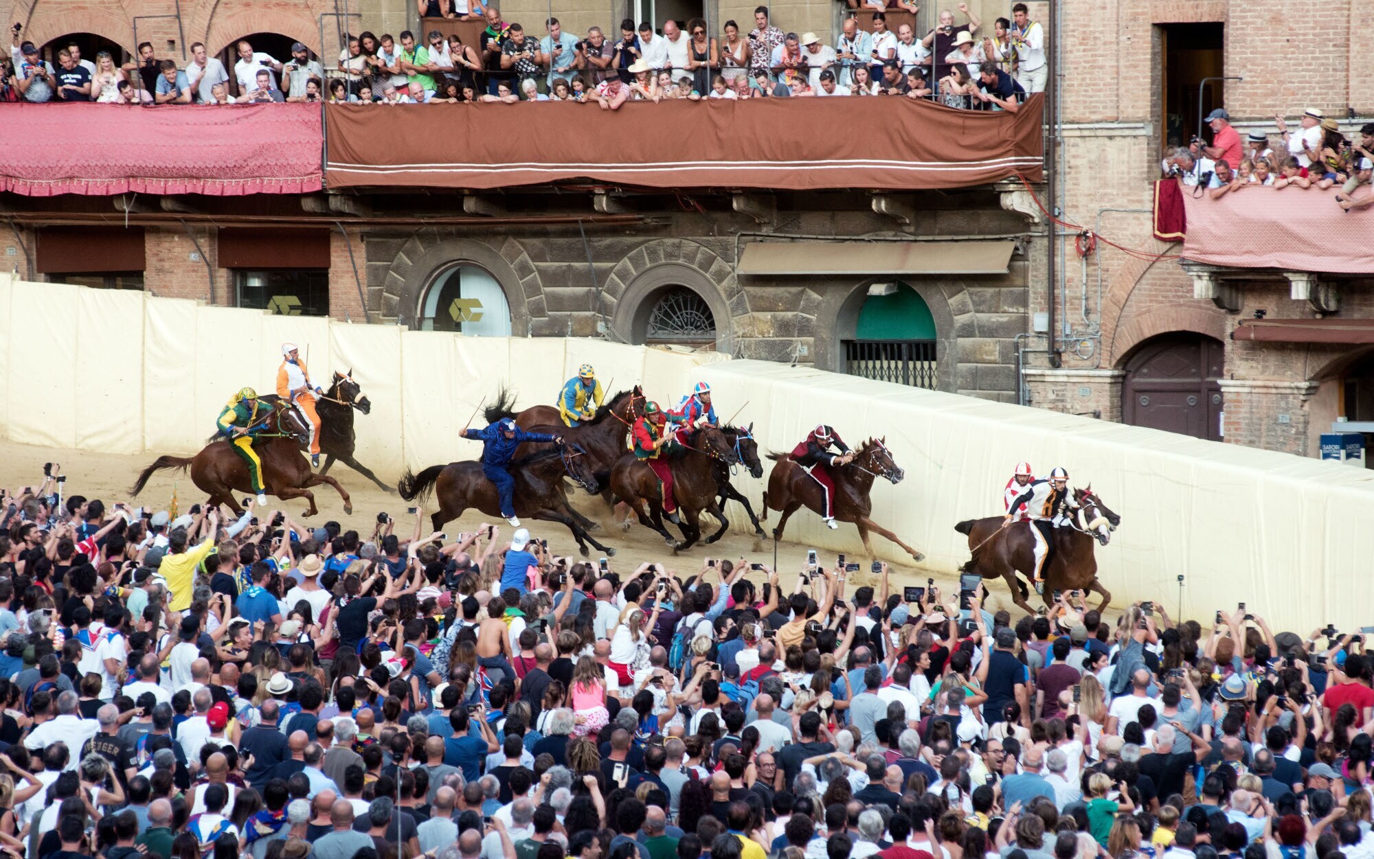 Reiter und Publikum beim Pferderennen Palio di Siena auf dem mittelalterlichen Platz der Stadt