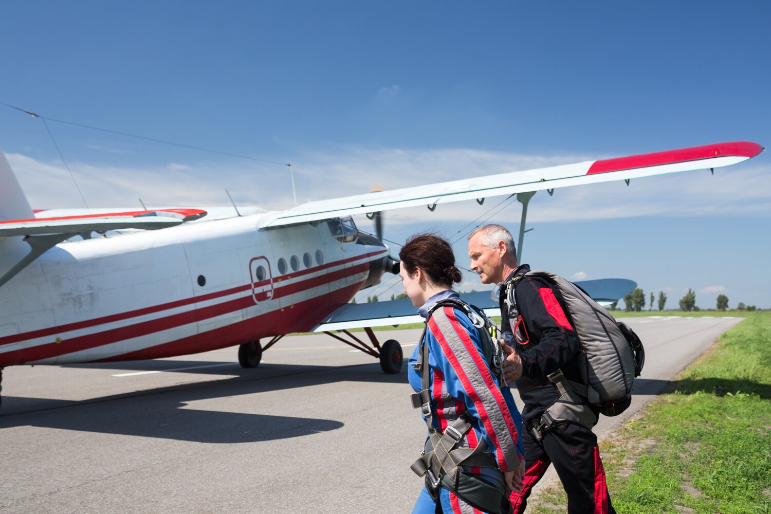 Zwei Personen laufen auf ein Flugzeug zu Zwei Personen laufen auf ein Flugzeug zu