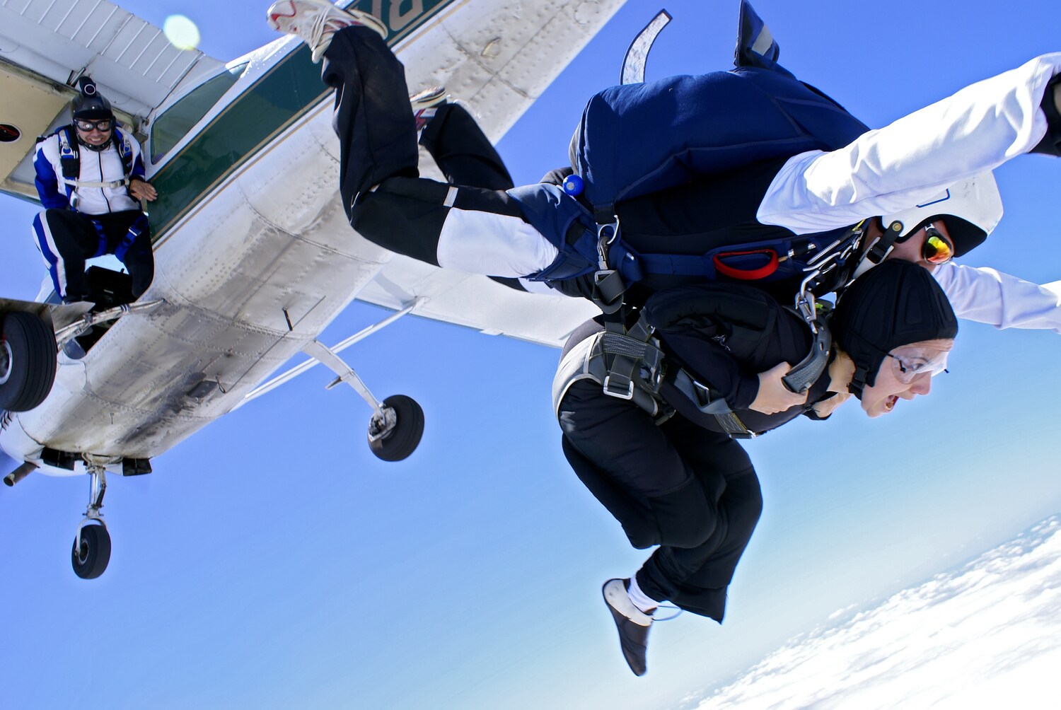 Zwei Menschen springen aus einem Flugzeug
