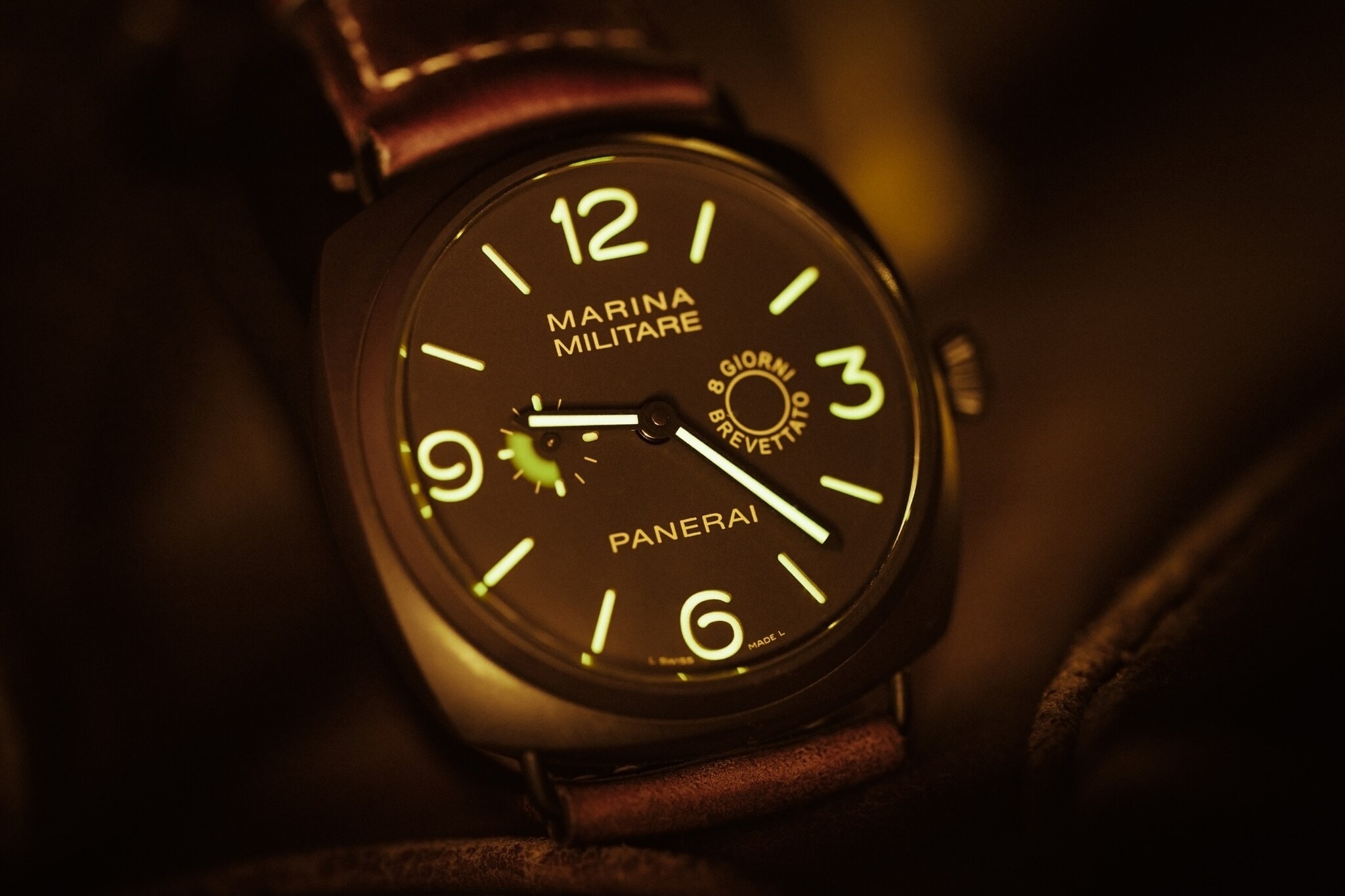 Nachleuchtende Zeiger und Ziffern auf dem Zifferblatt einer Panerai-Taucheruhr mit braunem Vintage-Lederarmband Nachleuchtende Zeiger und Ziffern auf dem Zifferblatt einer Panerai-Taucheruhr mit braunem Vintage-Lederarmband