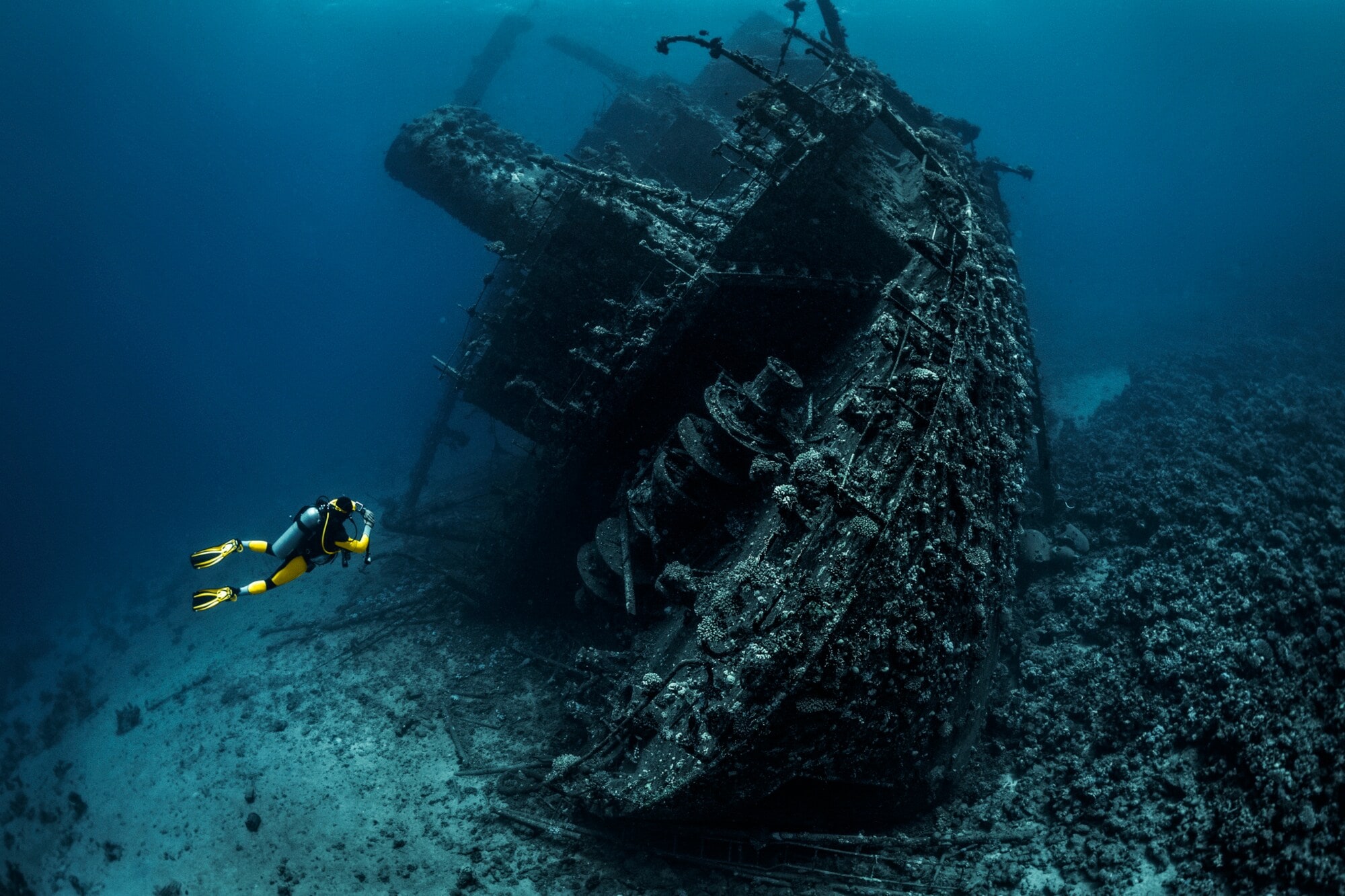 Taucher fotografiert das Wrack eines großen versunkenen Schiffes im Meer Taucher fotografiert das Wrack eines großen versunkenen Schiffes im Meer