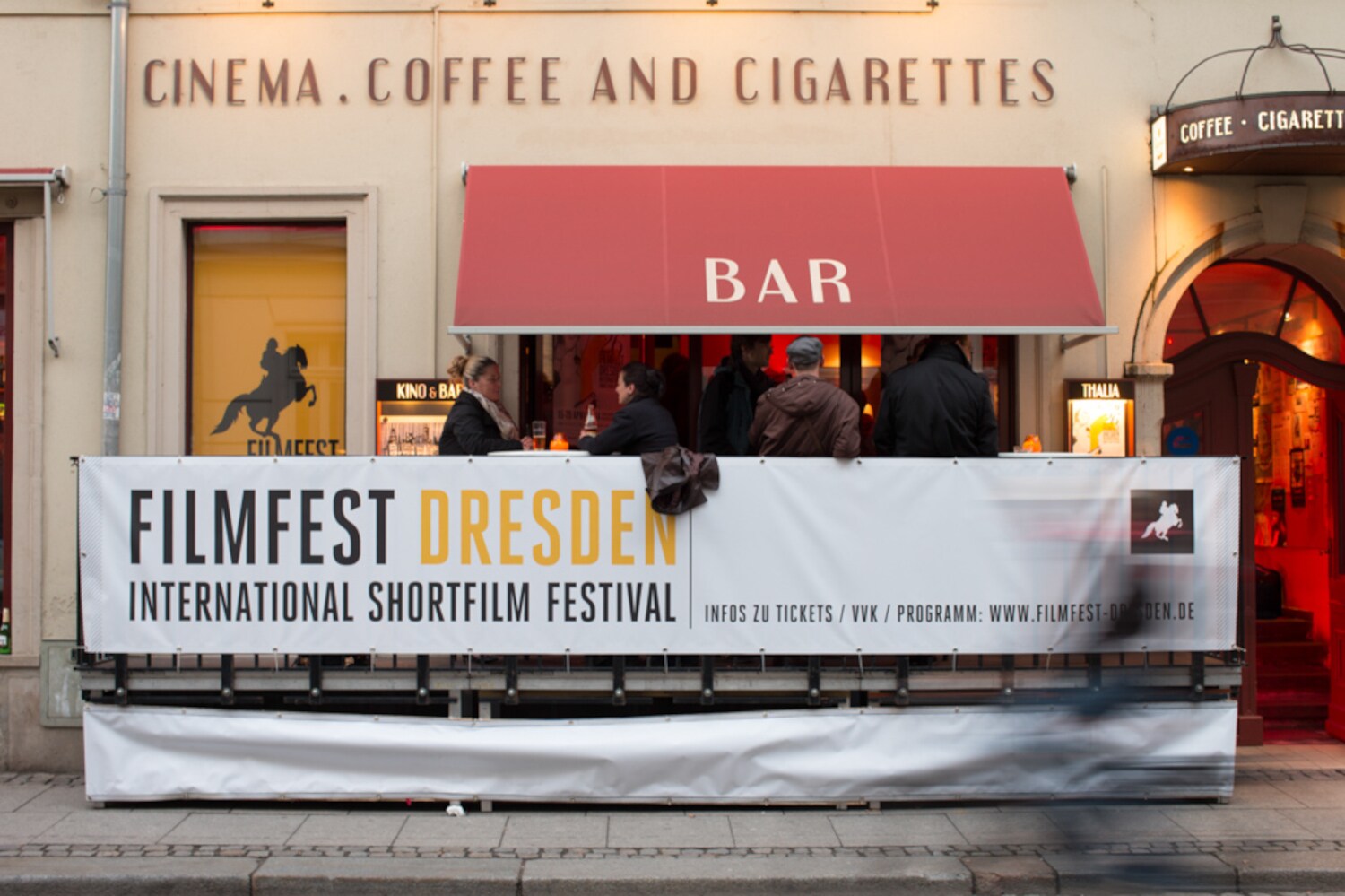 Ein Plakat für das Filmfest Dresden vor einer Bar