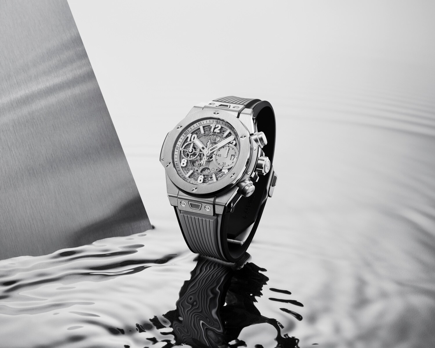 Schwarz-weiß-Aufnahme eines Chronografen auf spiegelndem Wasser