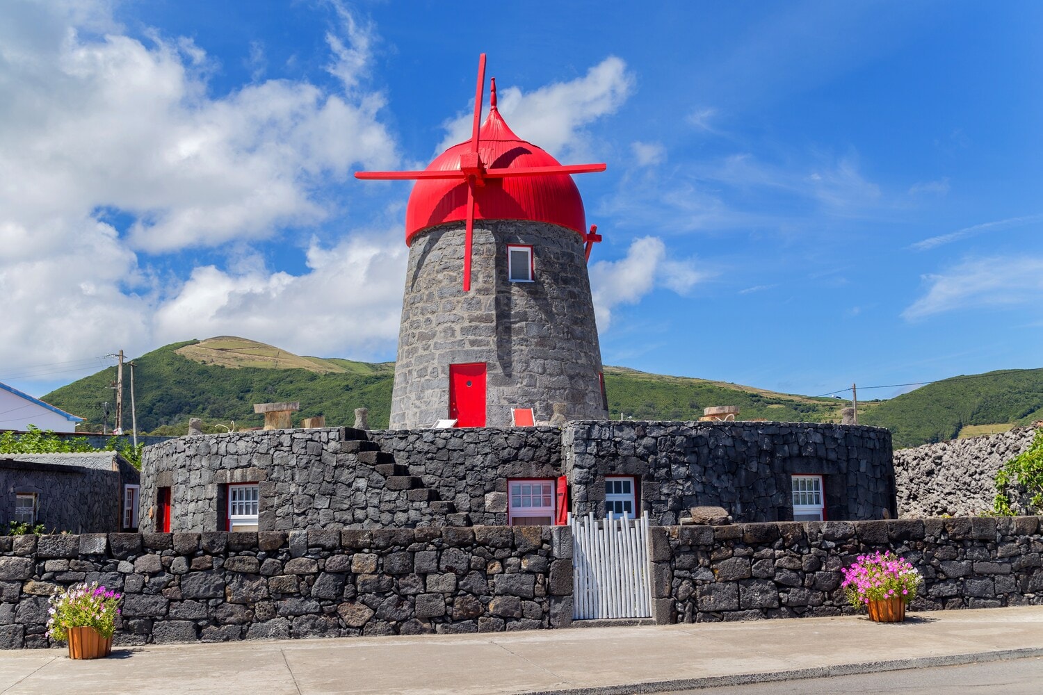 Eine Windmühle aus Stein mit rotem Dach Eine Windmühle aus Stein mit rotem Dach