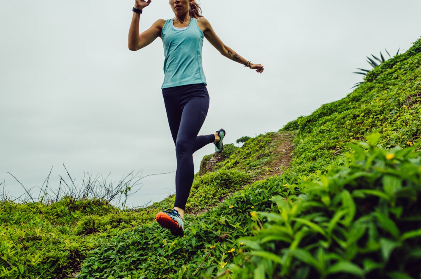 Eine junge Frau bergablaufend in Barfußschuhen