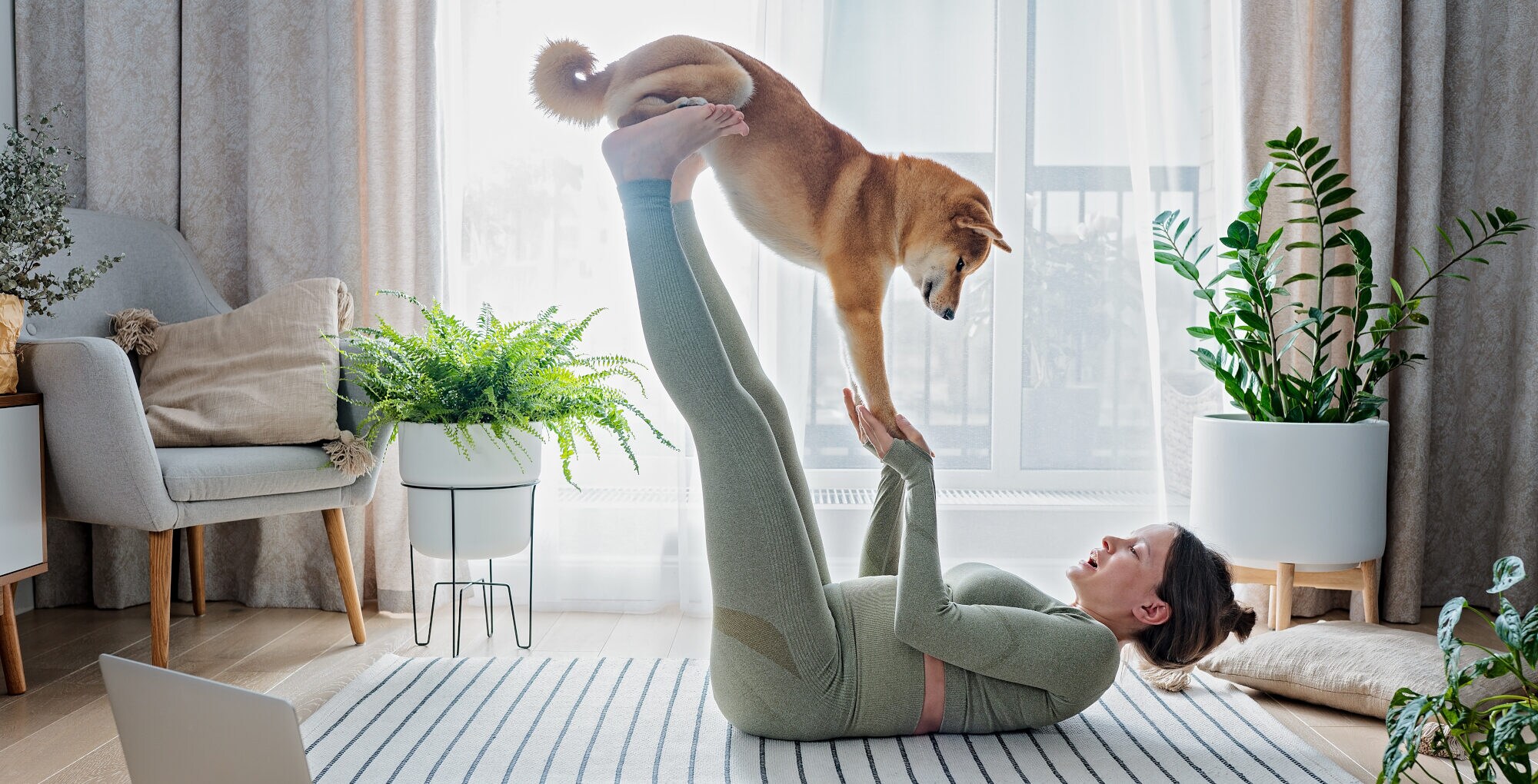 Eine junge Frau macht Yoga mit Hund
