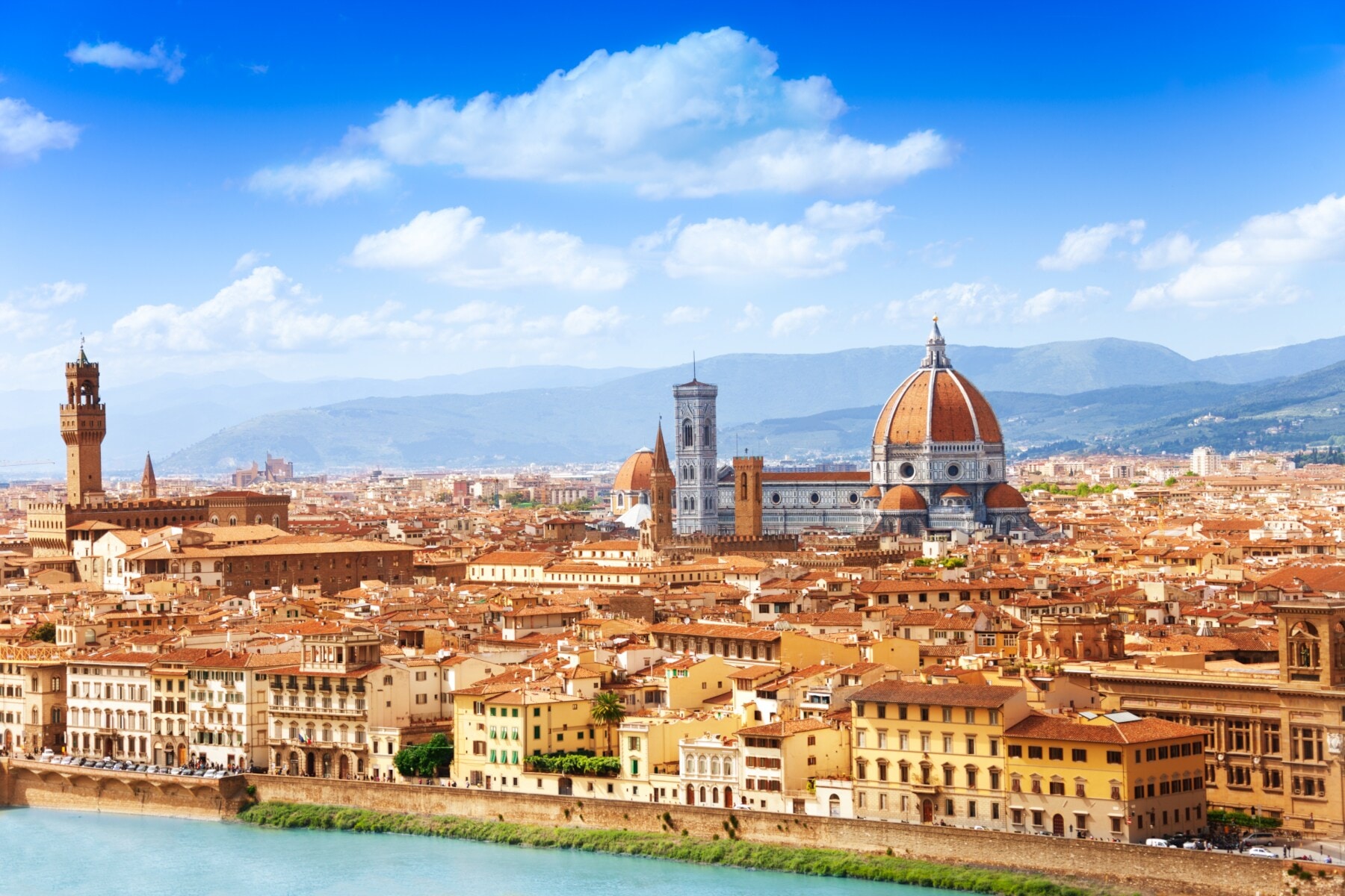 Blick auf eine mediterrane Stadt am Fluss mit historischen Gebäuden und einer Kathedrale Blick auf eine mediterrane Stadt am Fluss mit historischen Gebäuden und einer Kathedrale
