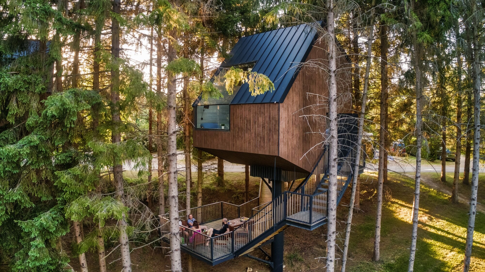 Ein Holzhaus, das zwischen den Baumkronen sitzt Ein Holzhaus, das zwischen den Baumkronen sitzt