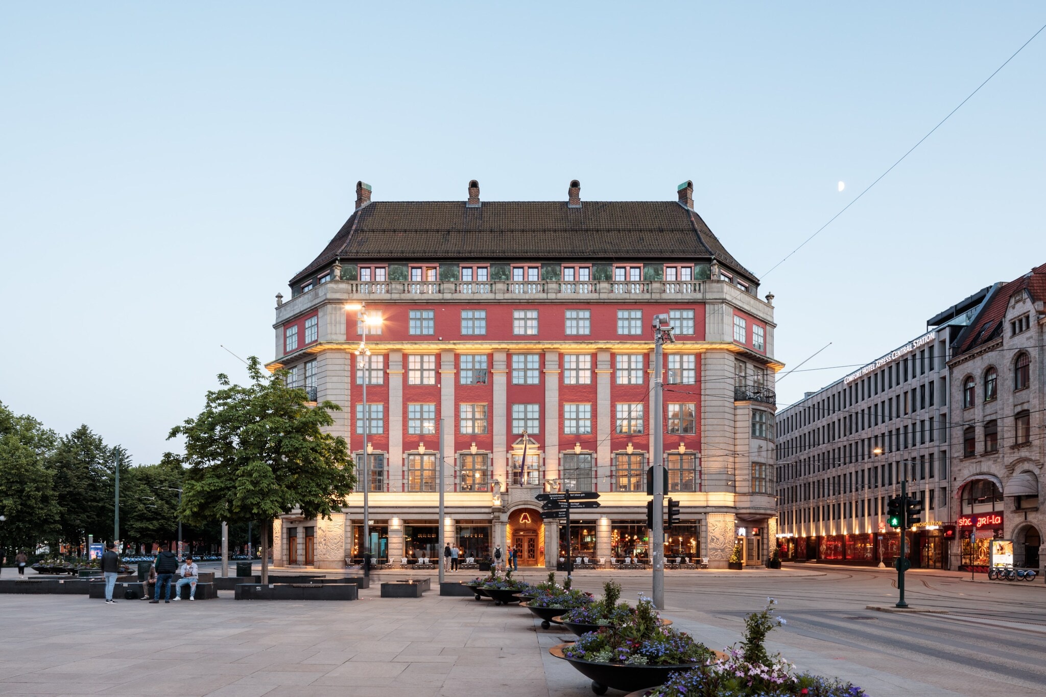 Prächtiges, beleuchtetes rotes Gebäude, davor ein großer Platz Prächtiges, beleuchtetes rotes Gebäude, davor ein großer Platz