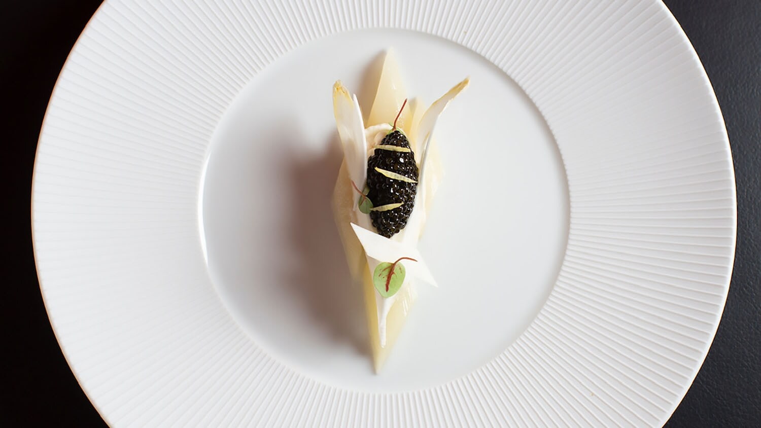 Aufsicht eines reduzierten Gourmet-Gerichtes mit weißem Spargel auf einem weißen Teller Aufsicht eines reduzierten Gourmet-Gerichtes mit weißem Spargel auf einem weißen Teller