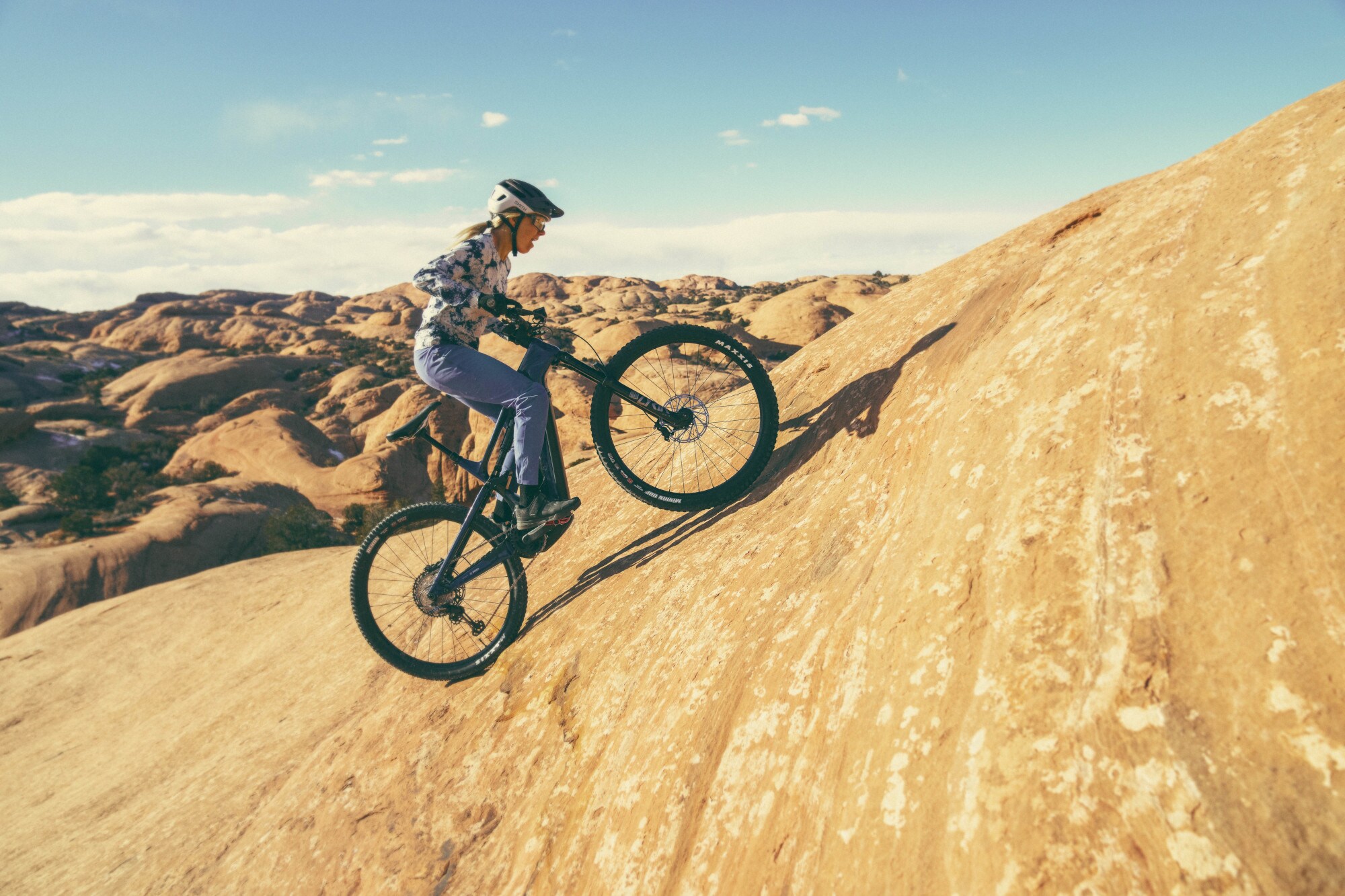 Eine Radfahrerin auf einem Pedelec fährt bergauf