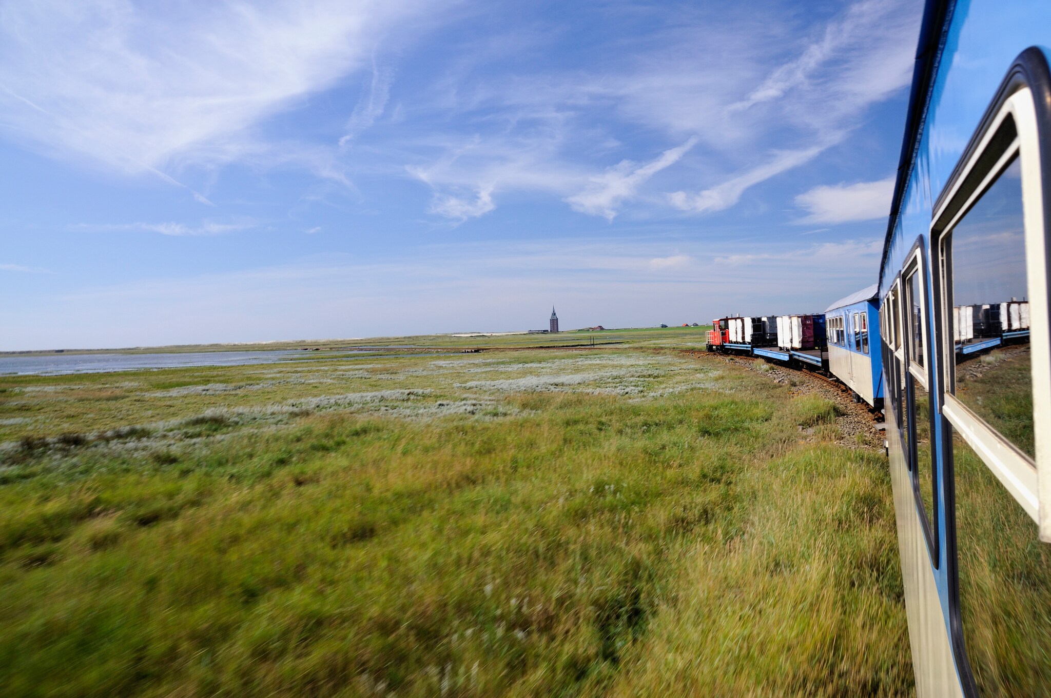 Blick aus einer Eisenbahn, die durch eine sumpfige Grasebene fährt