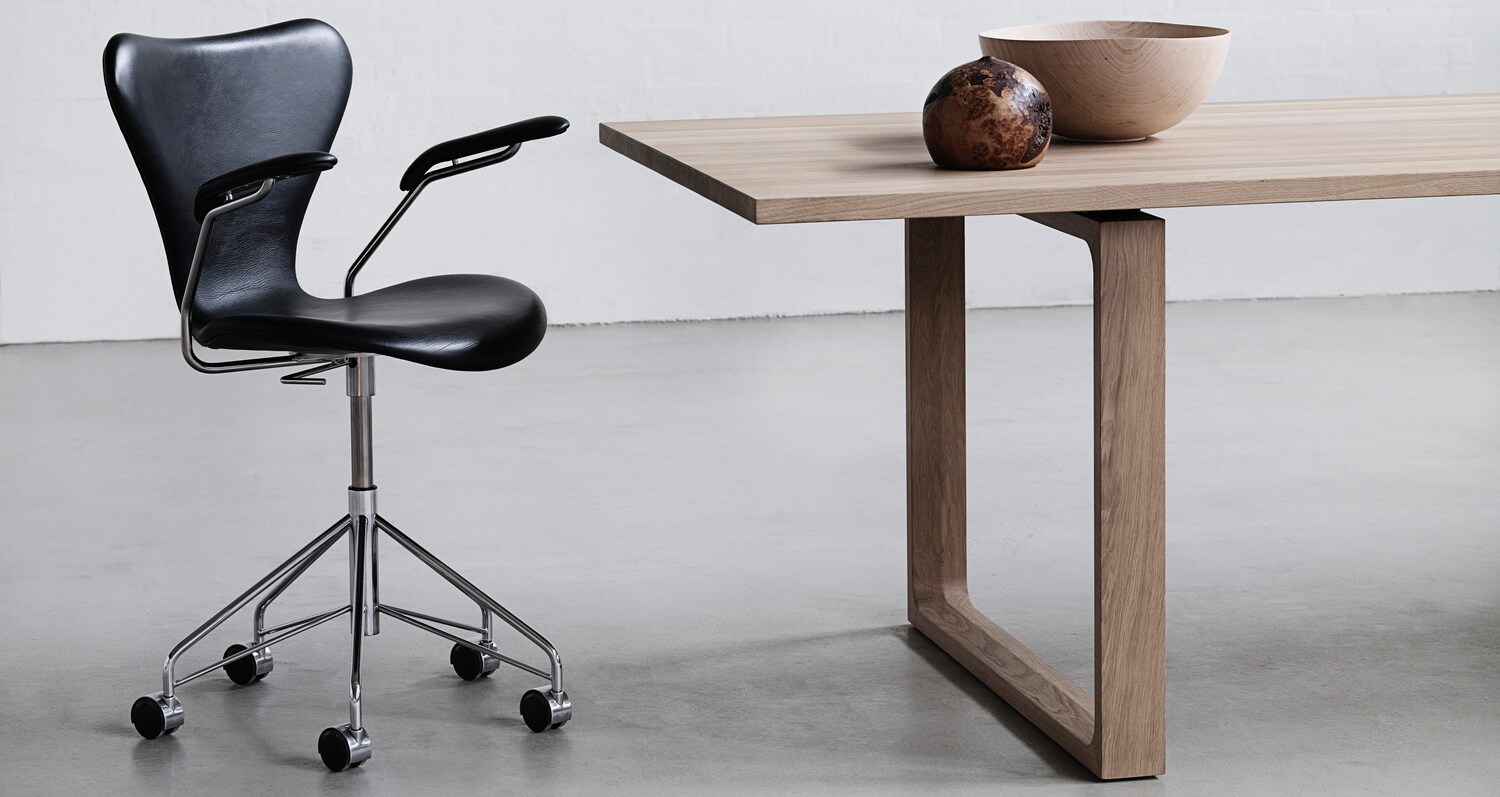 Ein eleganter Drehstuhl im Arne-Jacobsen-Design mit schwarzem Lederbezug und verchromten Gestell auf Rollen Ein eleganter Drehstuhl im Arne-Jacobsen-Design mit schwarzem Lederbezug und verchromten Gestell auf Rollen