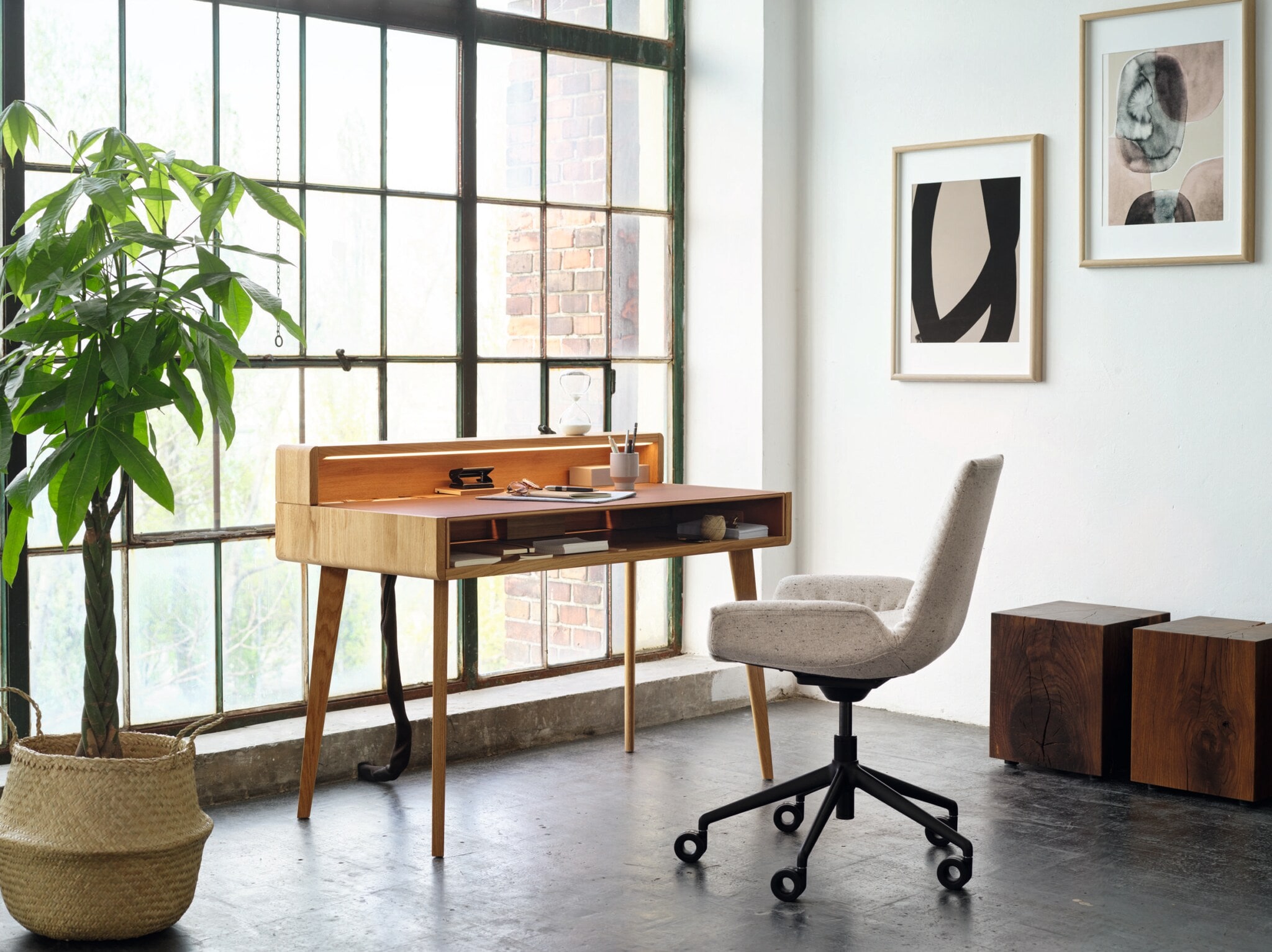 Ein weißer Bürodrehstuhl mit weicher Schale und schwarzem Gestell auf Rollen an einem modernen Arbeitsplatz in einer Wohnung Ein weißer Bürodrehstuhl mit weicher Schale und schwarzem Gestell auf Rollen an einem modernen Arbeitsplatz in einer Wohnung