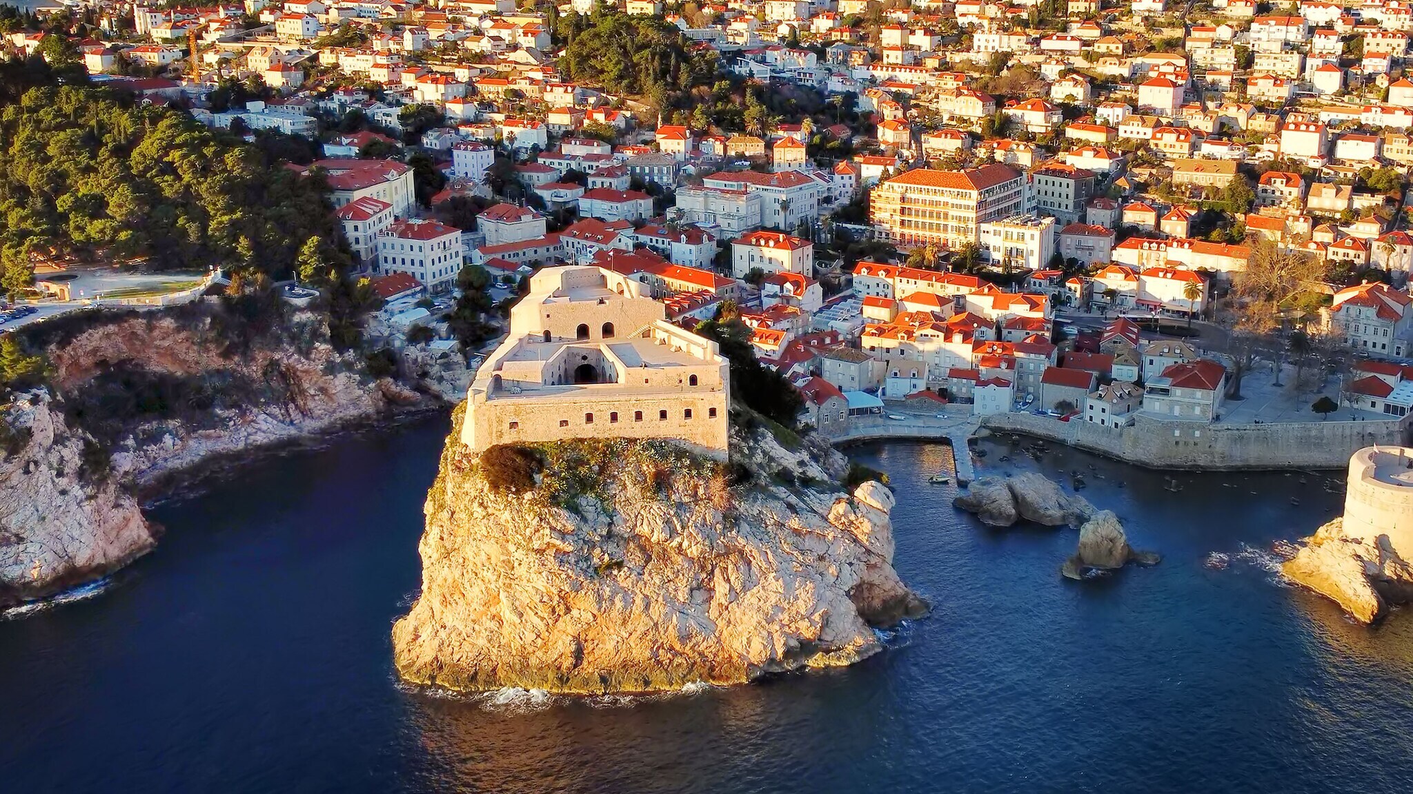 Luftaufnahme einer Festung auf einem hohen Felsen im Wasser vor der Stadt Dubrovnik