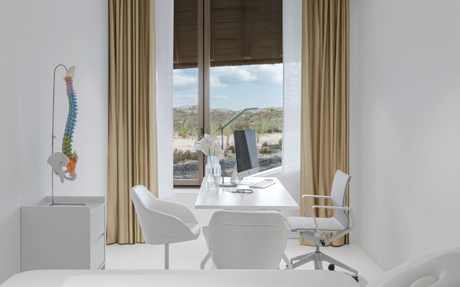 Ein moderner eingerichteter ärztlicher Behandlungsraum mit Blick in die Dünen