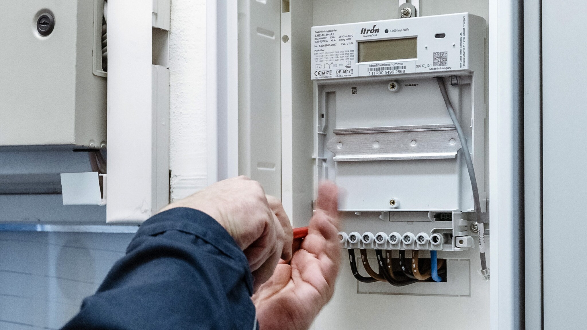 Ein digitaler Stromzähler wird an eine Wand montiert