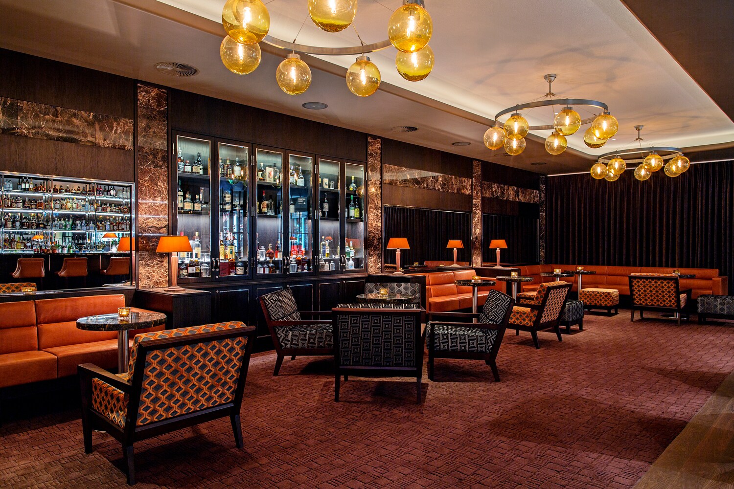 Loungeartiger Bereich mit einer Bar und gedimmter Beleuchtung.