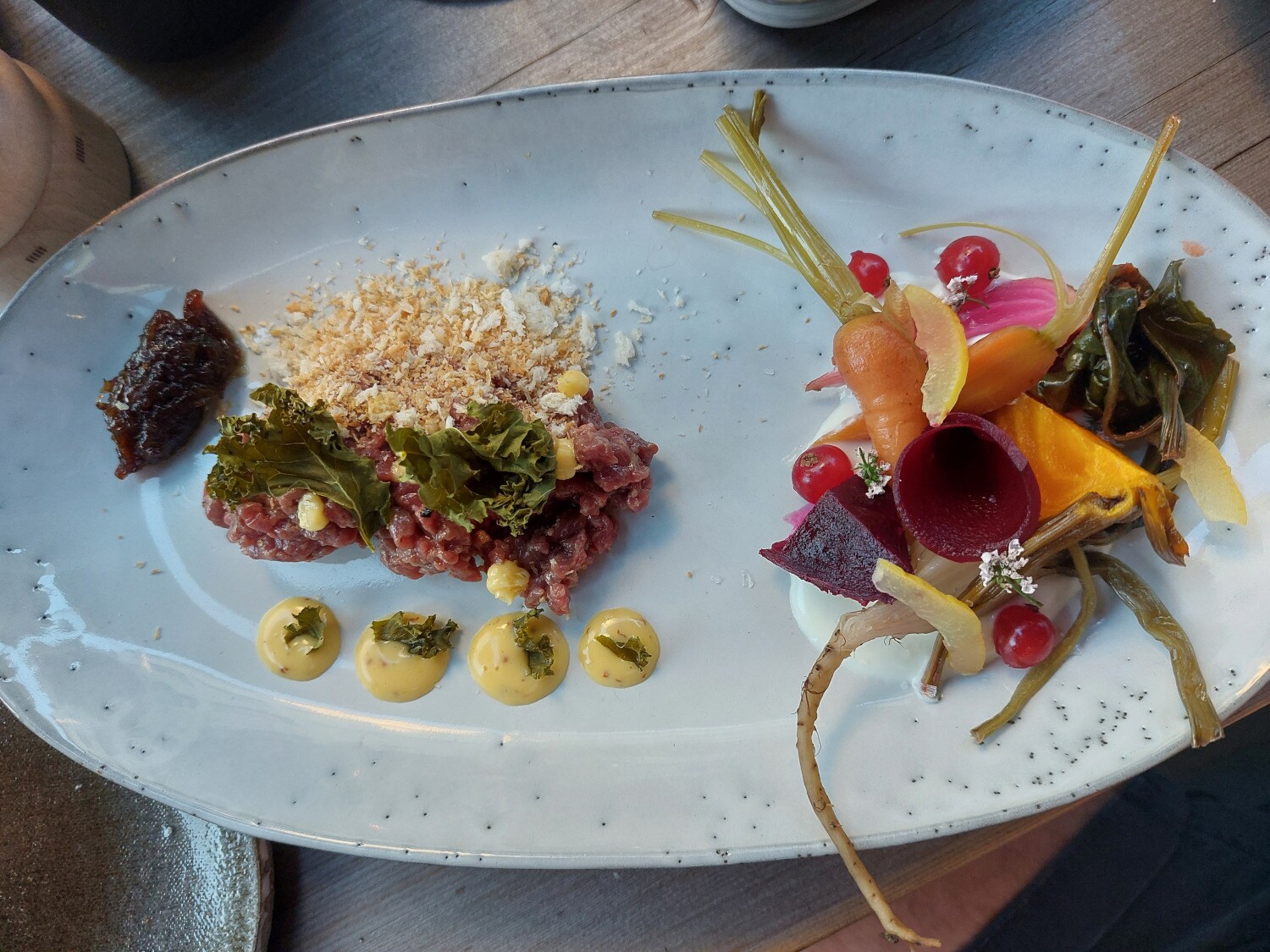 Beef Tartar und Sommerrübenvariationen auf einem Teller angerichtet