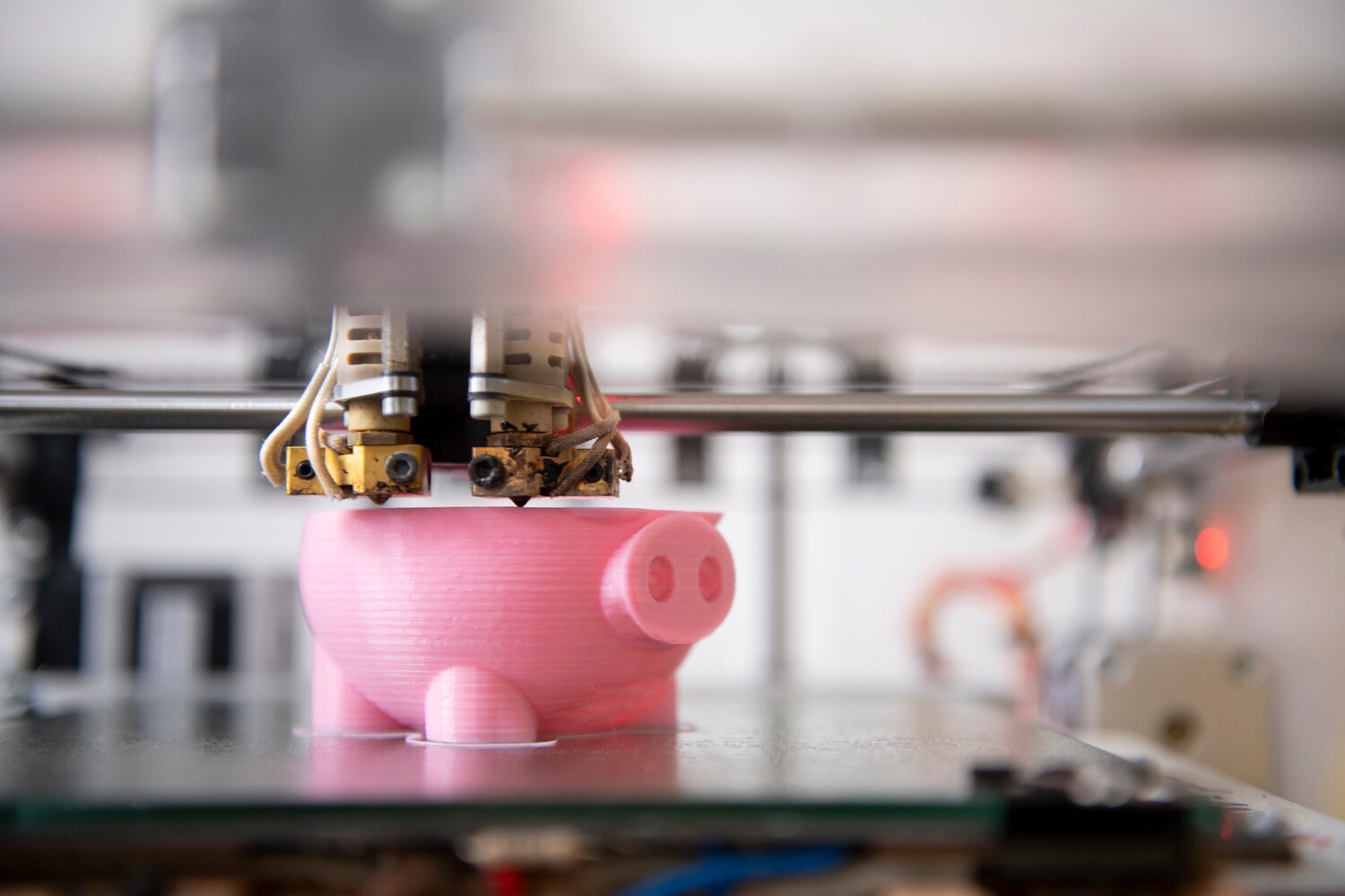 Ein 3D-Modell in Schweineform aus rosa Kunststoff wird in einem 3D-Drucker erstellt
