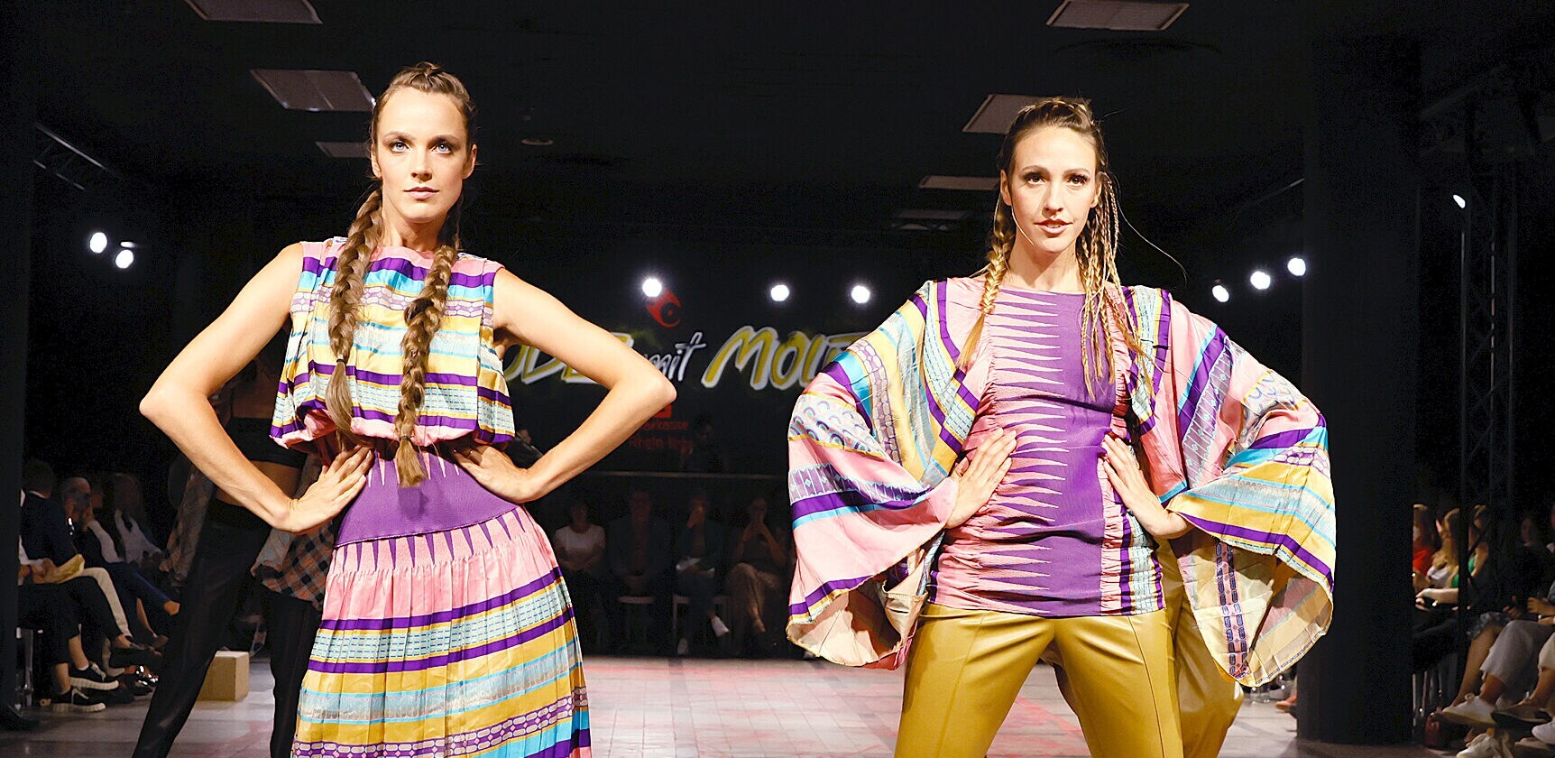Zwei Models in gemusterten Outfits nebeneinander auf dem Runway