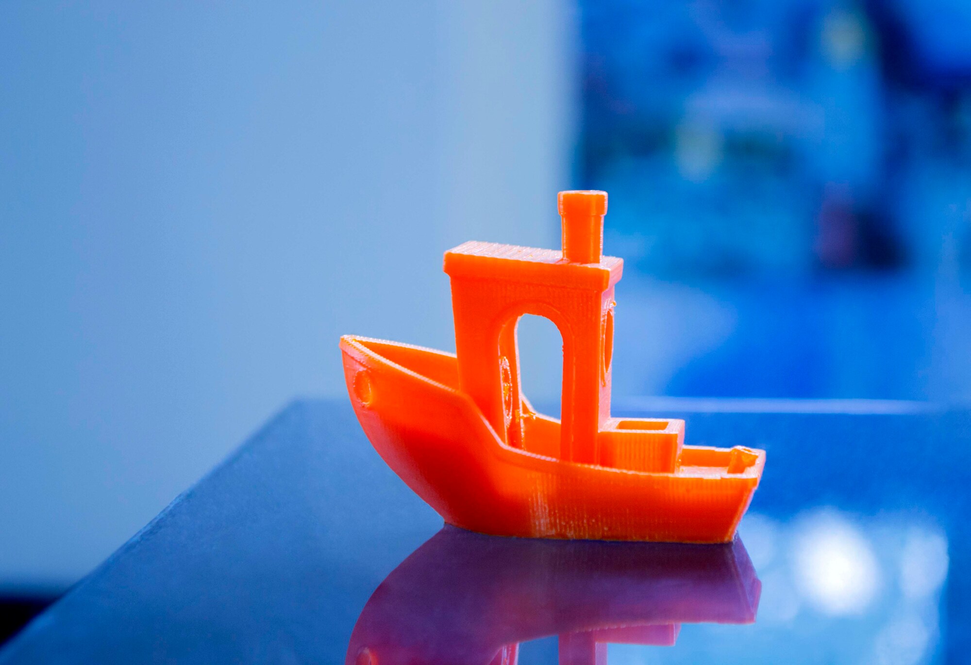 Ein kleines, mit einem 3D-Drucker erstelltes Modellboot aus orangenem Plastik