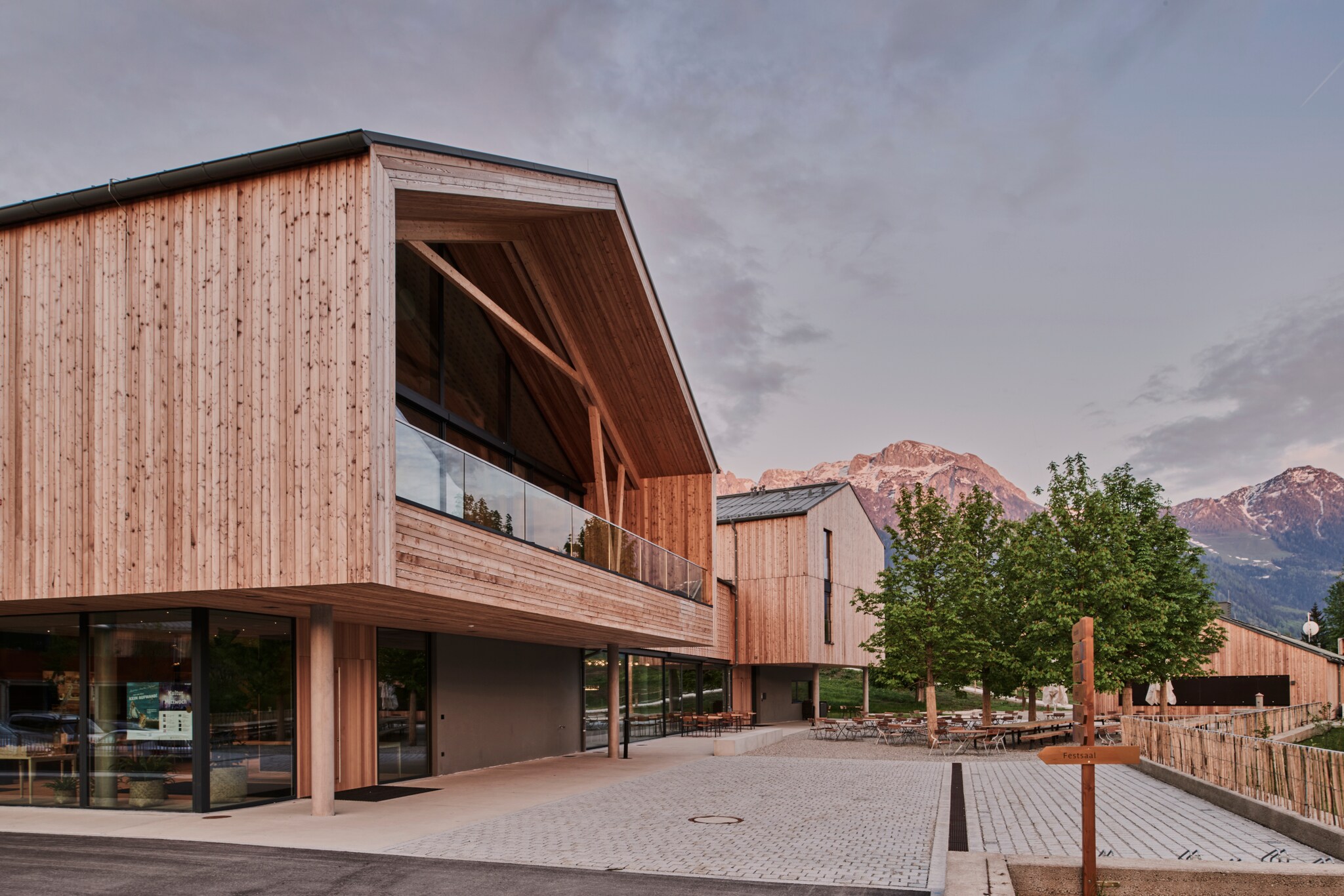 Ein moderner Hotelkomplex aus Holz vor Bergkulisse
