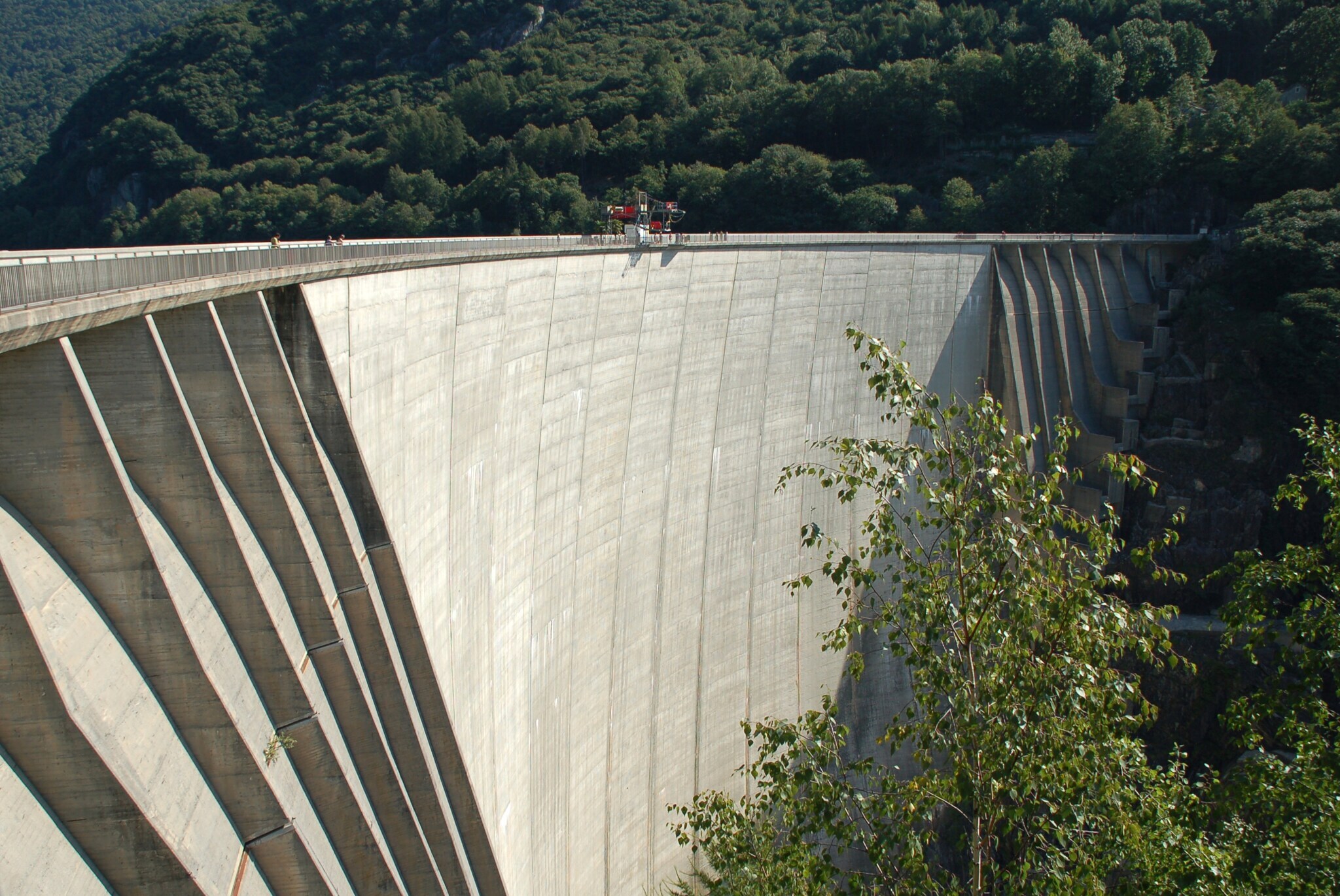 Ein Staudamm, auf dem Menschen stehen, die einen Bungeesprung absolvieren wollen