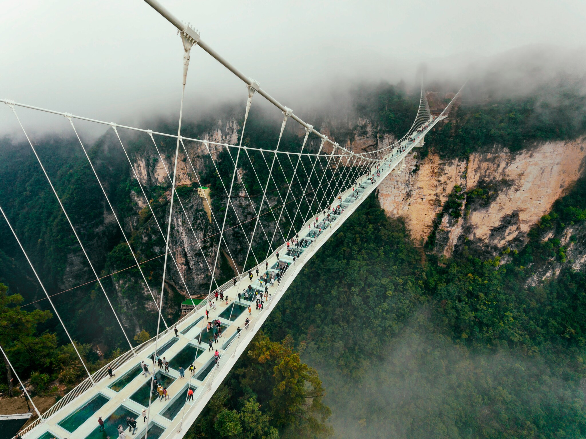 Eine gläserne Brücke die über einen tiefen Abgrund führt Eine gläserne Brücke die über einen tiefen Abgrund führt