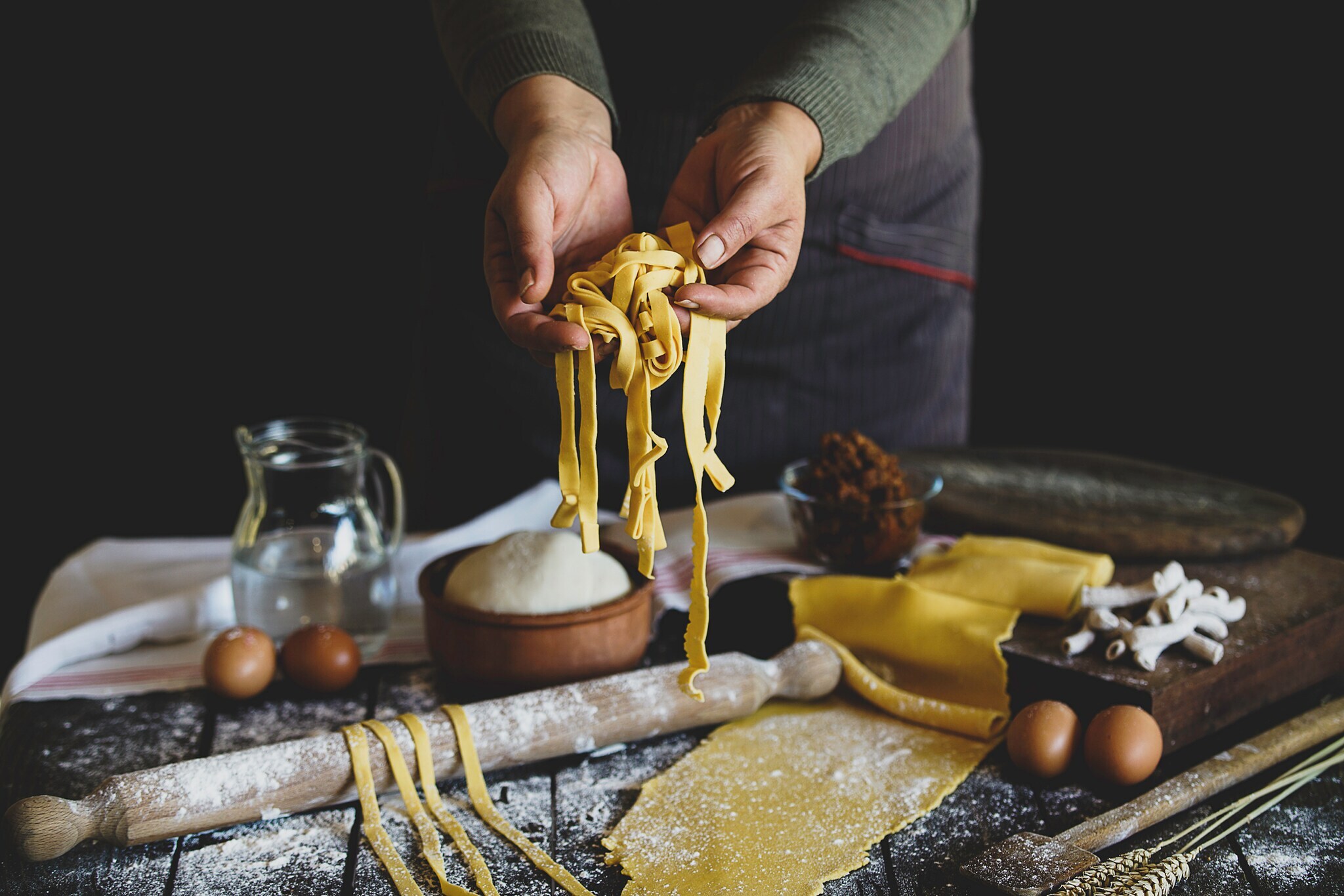 Eine Person hält selbstgemachte Pasta in die Kamera Eine Person hält selbstgemachte Pasta in die Kamera