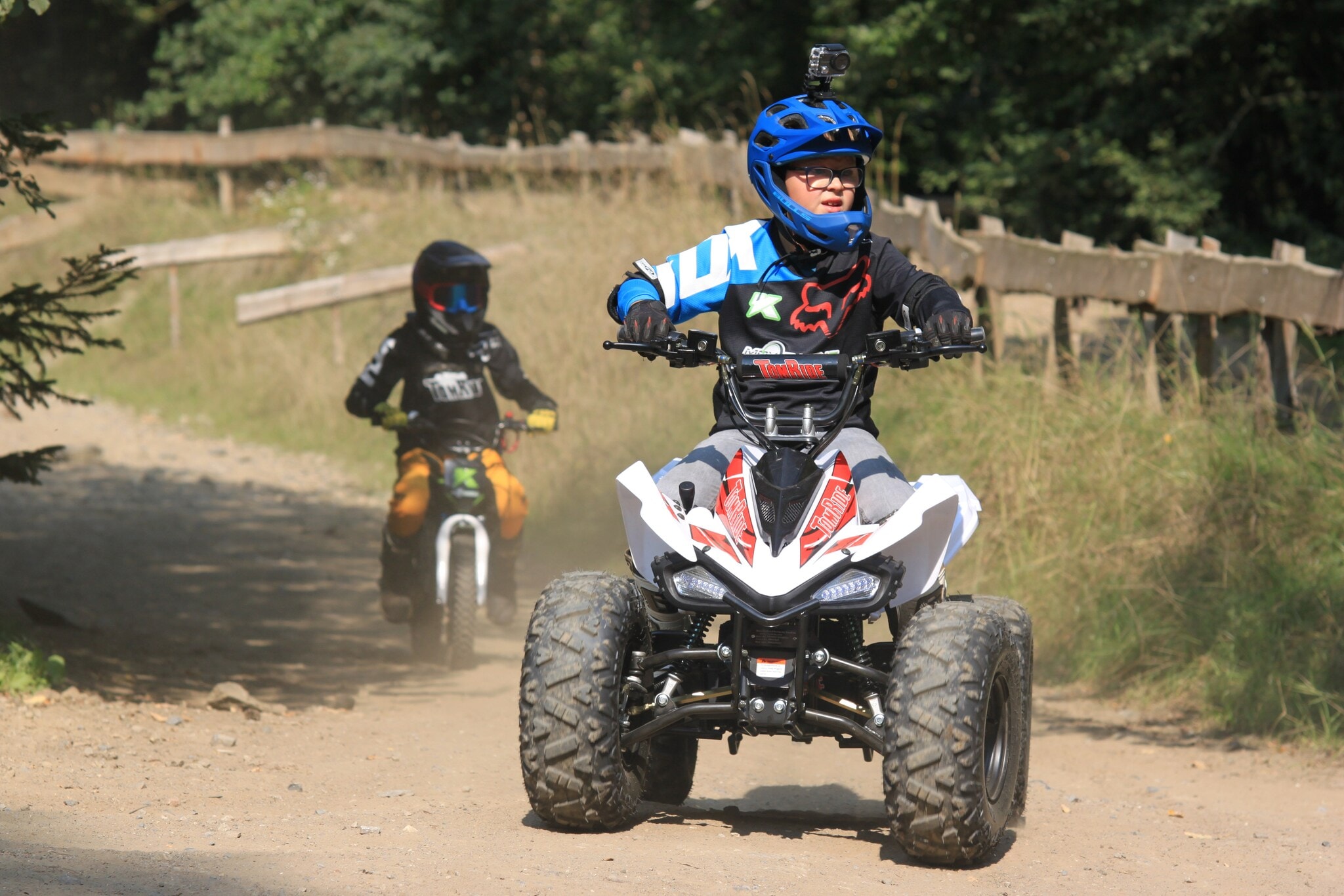 Ein Junge fährt auf einem E-Quad über unbefestigtes Gelände. Ein Junge fährt auf einem E-Quad über unbefestigtes Gelände.
