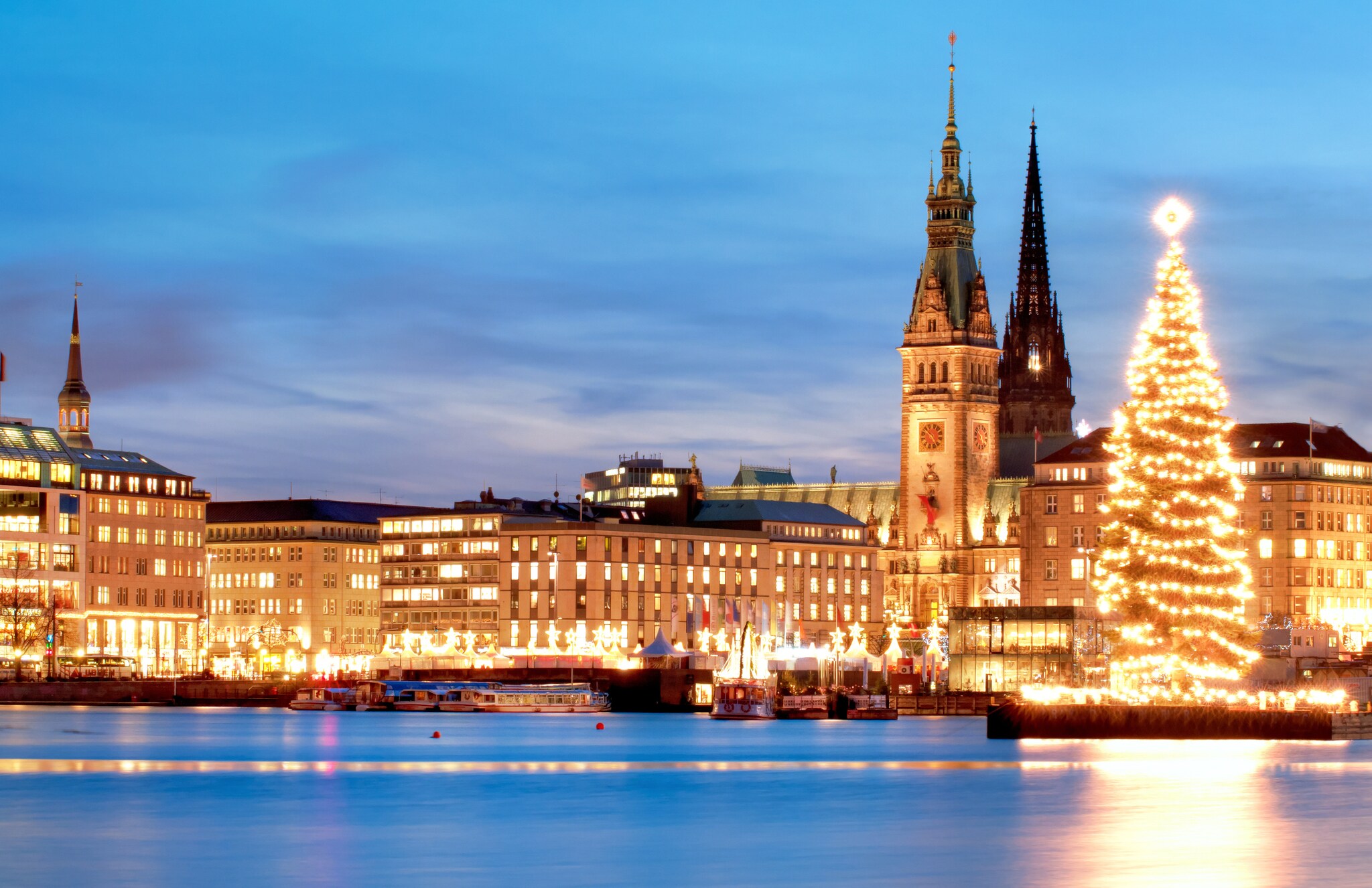 Erleuchtetes Panorama von Hamburg mit Rathaus und Weihnachtsbaum an der Alster