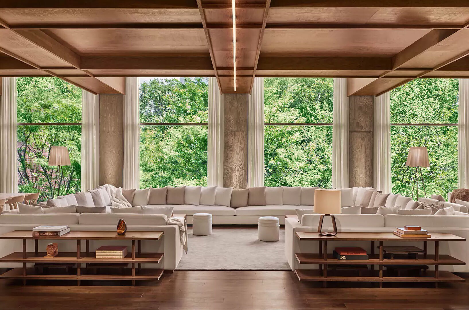 Hotellobby mit beigen Sofas und großen Fenstern.