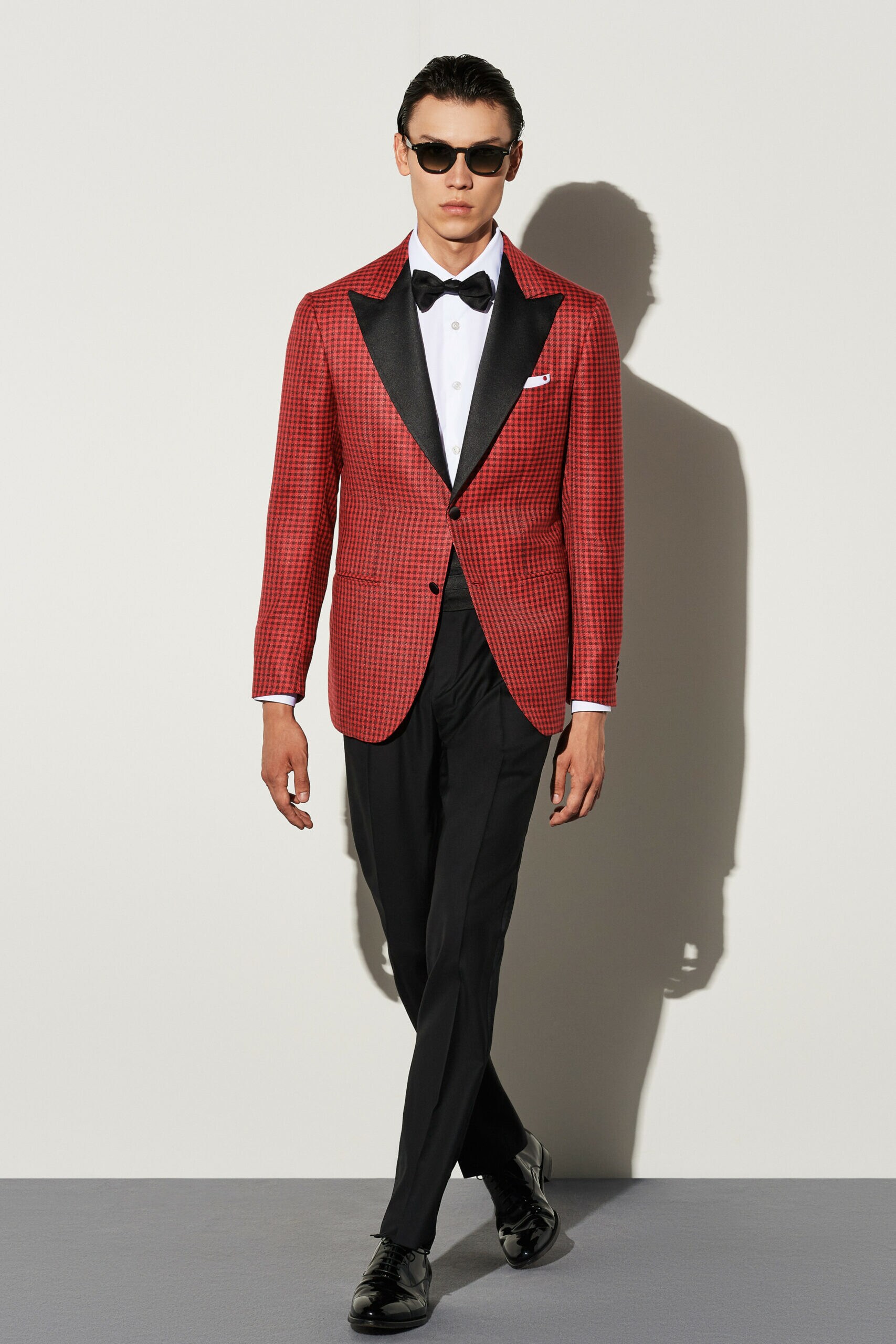 Ein männliches Model posiert in einem roten Smoking mit Fliege Ein männliches Model posiert in einem roten Smoking mit Fliege