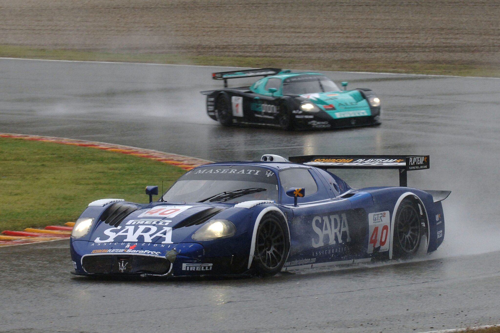 Zwei Rennwagen auf einer Rennstrecke im Regen