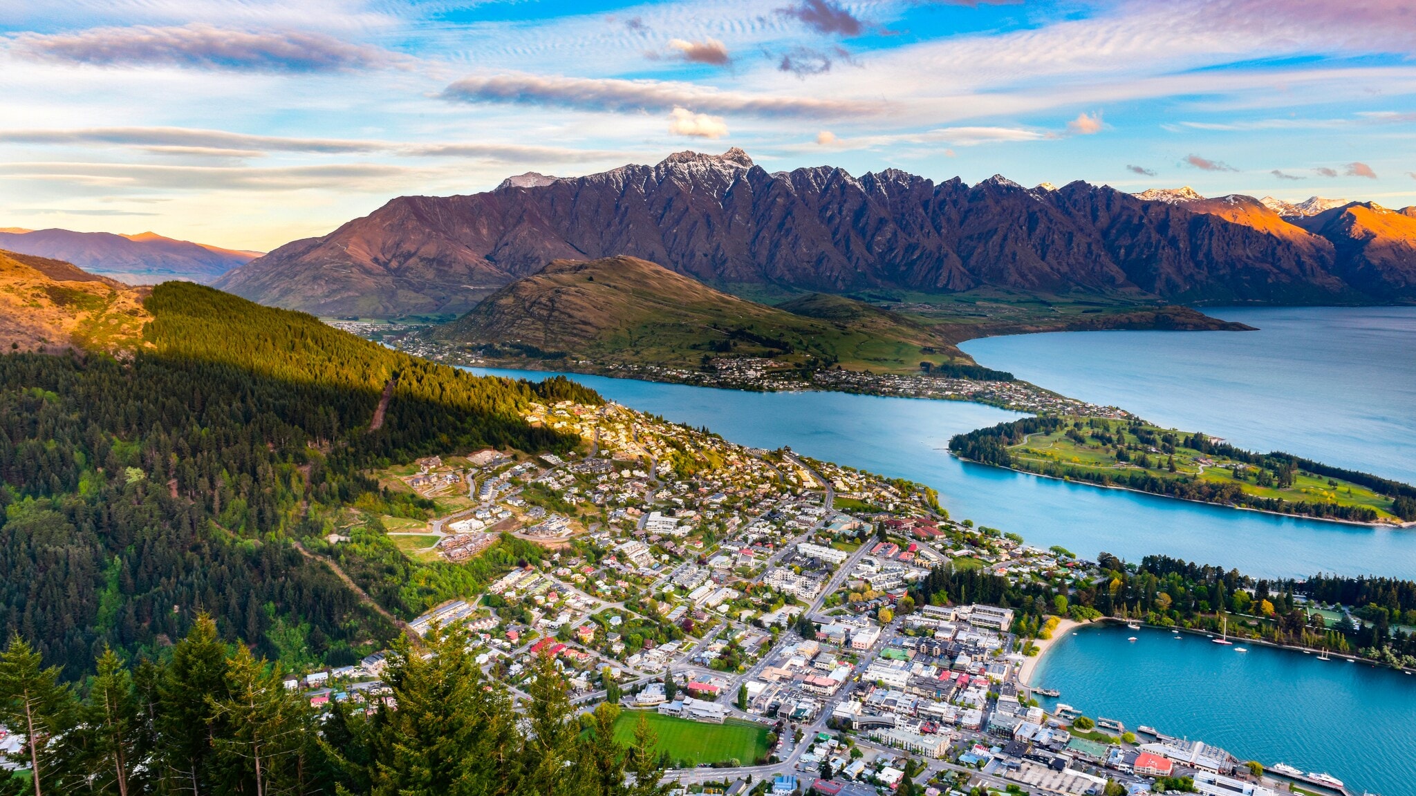 Blick über eine Küstenstadt, die von einer Bergkette gesäumt wird Blick über eine Küstenstadt, die von einer Bergkette gesäumt wird
