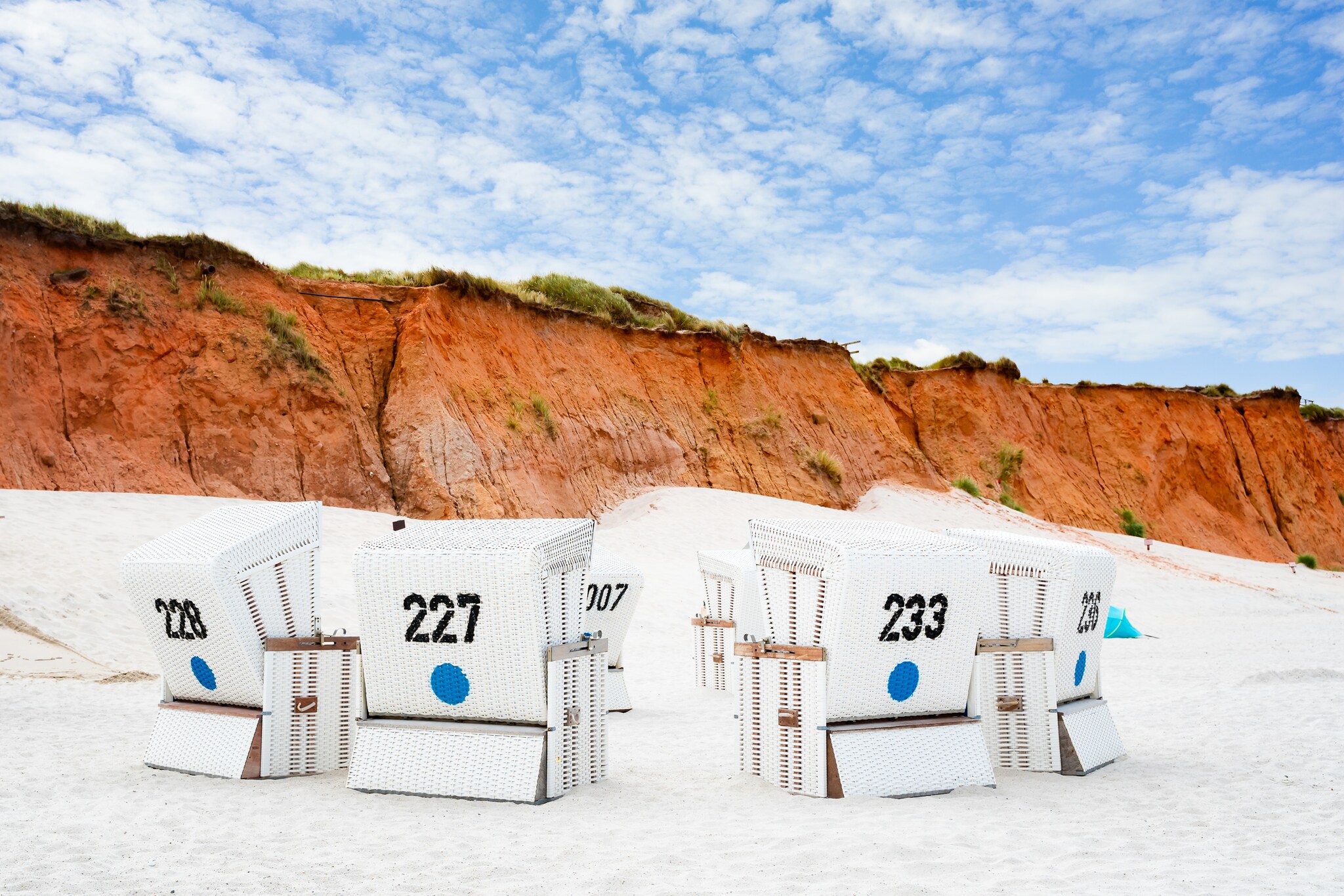 Strandkörbe auf der Insel Sylt am Strand vor roten Klippen