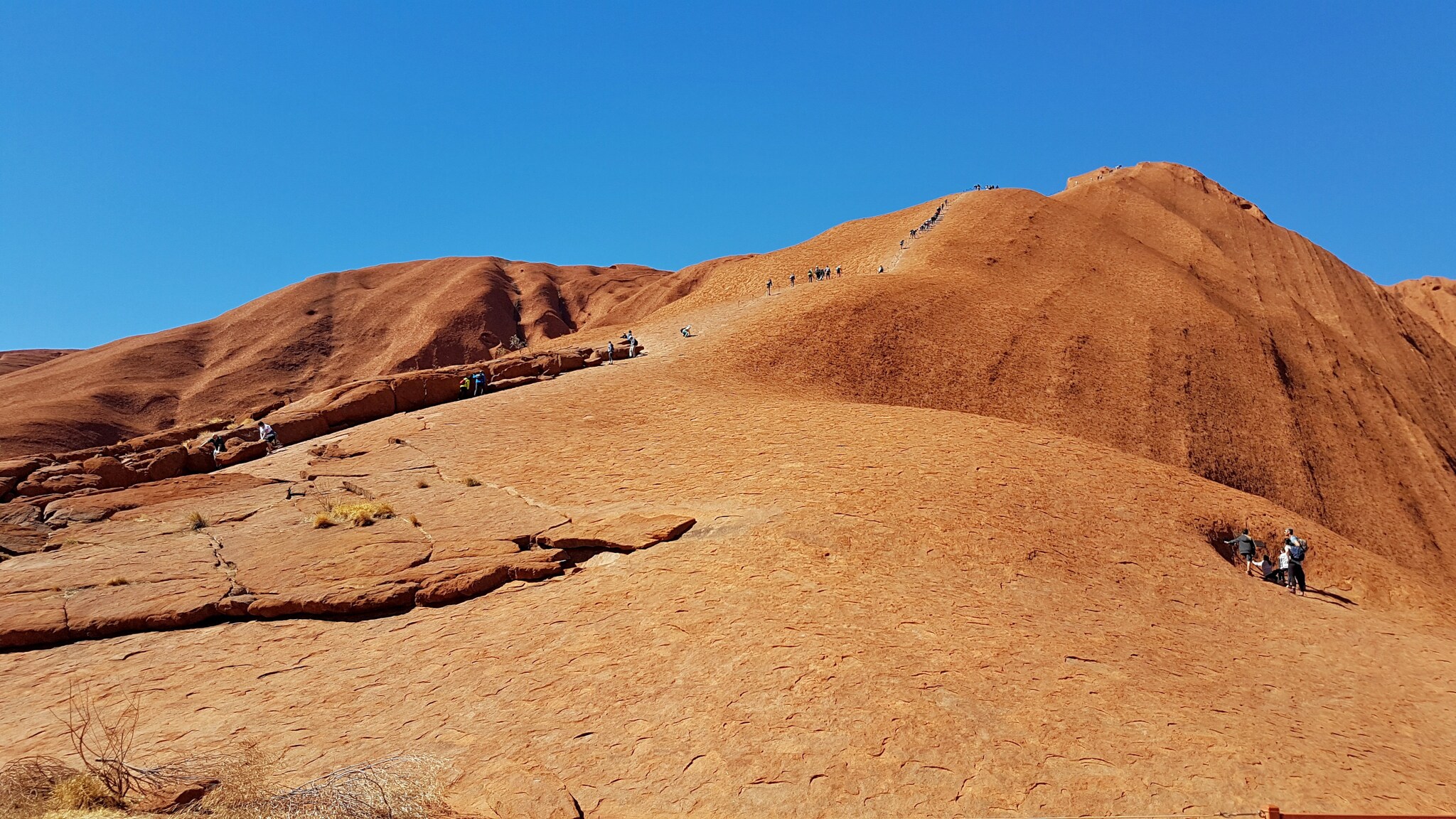 Touristen und Touristinnen auf dem roten Berg Uluru