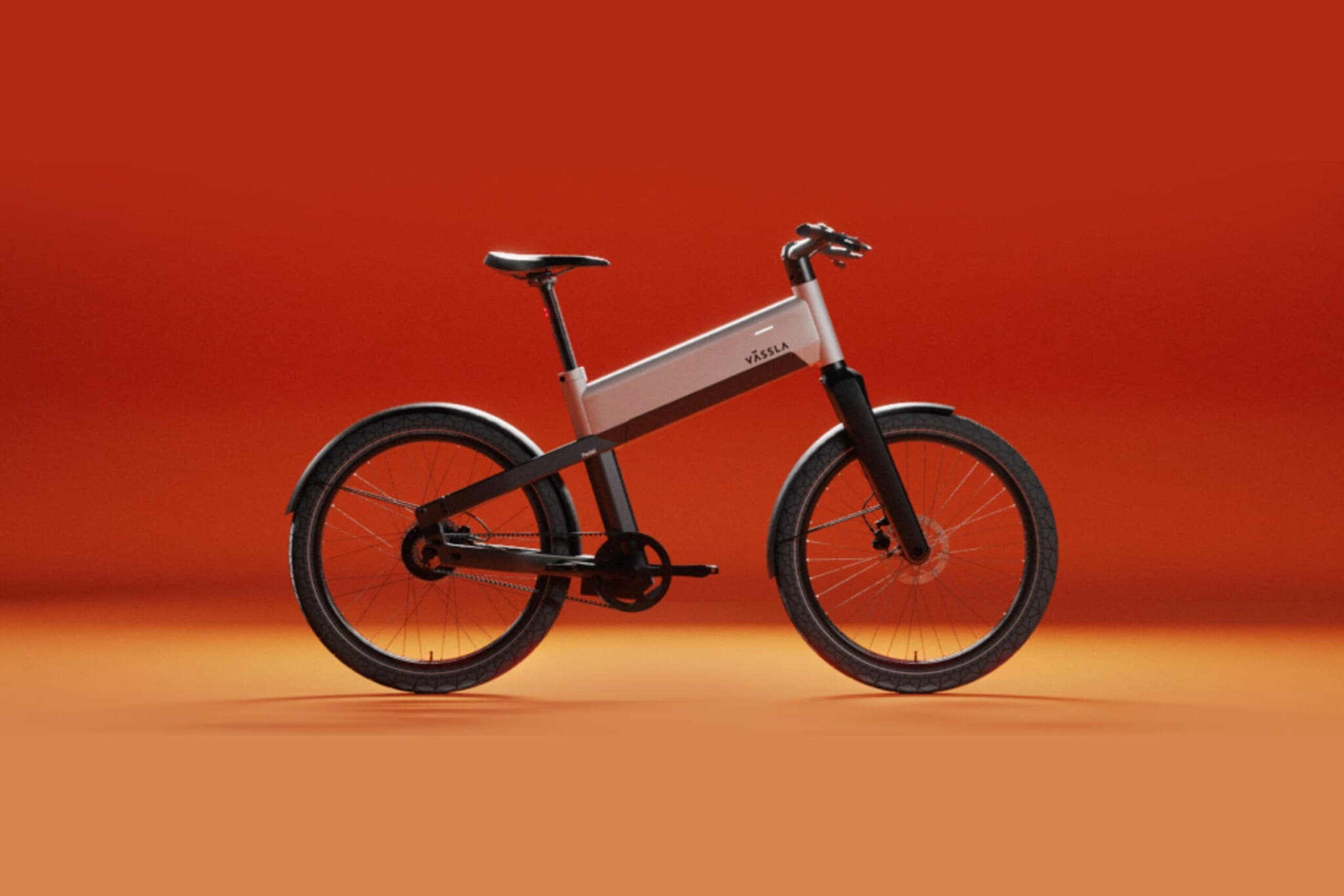 Ein schwarz-silbernes E-Bike der Marke Vässla vor rot-orangenem Hintergrund Ein schwarz-silbernes E-Bike der Marke Vässla vor rot-orangenem Hintergrund