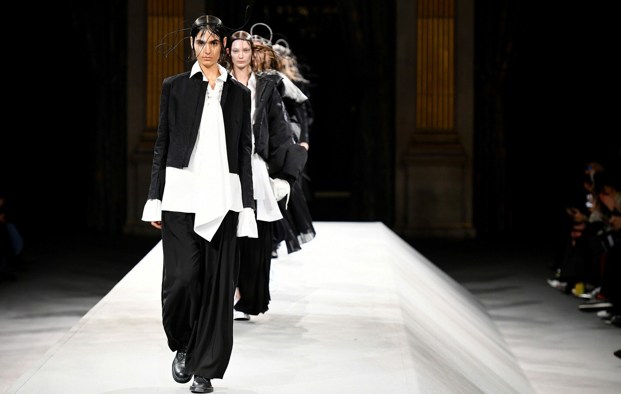 Mehrere Models laufen über einen Catwalk im Zuge einer Fashionshow. Mehrere Models laufen über einen Catwalk im Zuge einer Fashionshow.