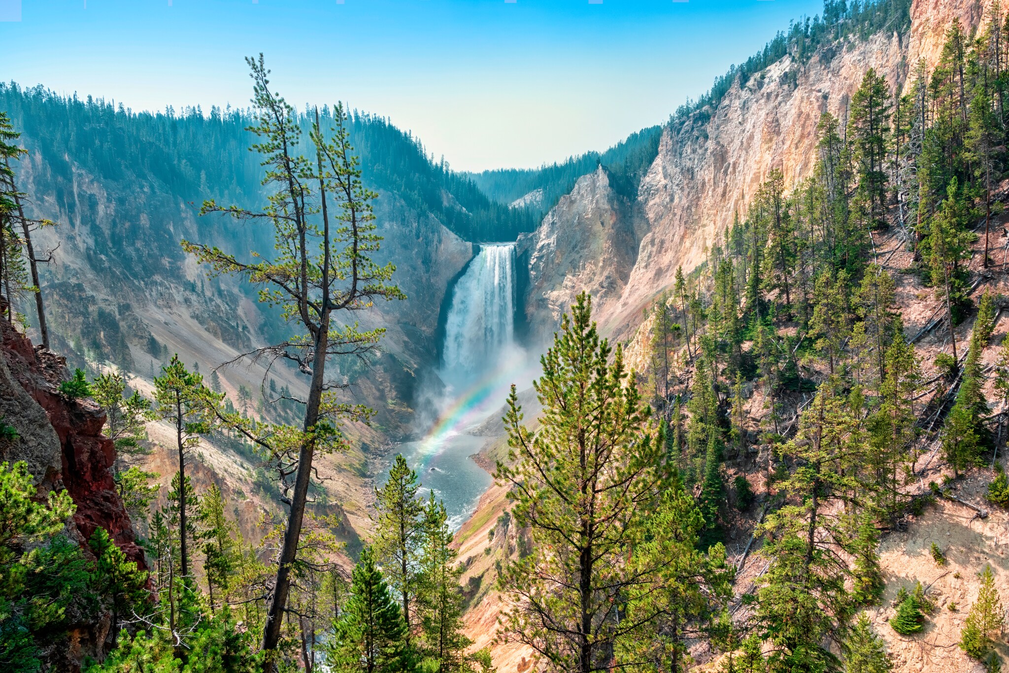 Blick auf einen Wasserfall, der in die Tiefe rauscht. Davor zeichnet sich ein kleiner Regenbogen ab. Blick auf einen Wasserfall, der in die Tiefe rauscht. Davor zeichnet sich ein kleiner Regenbogen ab.
