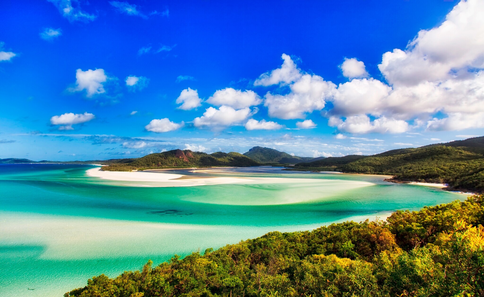 Landschaft mit Strand, Meer, Hügeln und Bäumen