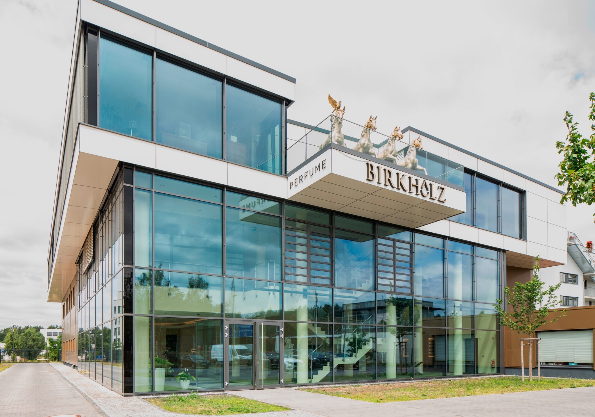Kubistisches Glasgebäude der Firma Birkholz mit Quadriga auf der Terrasse