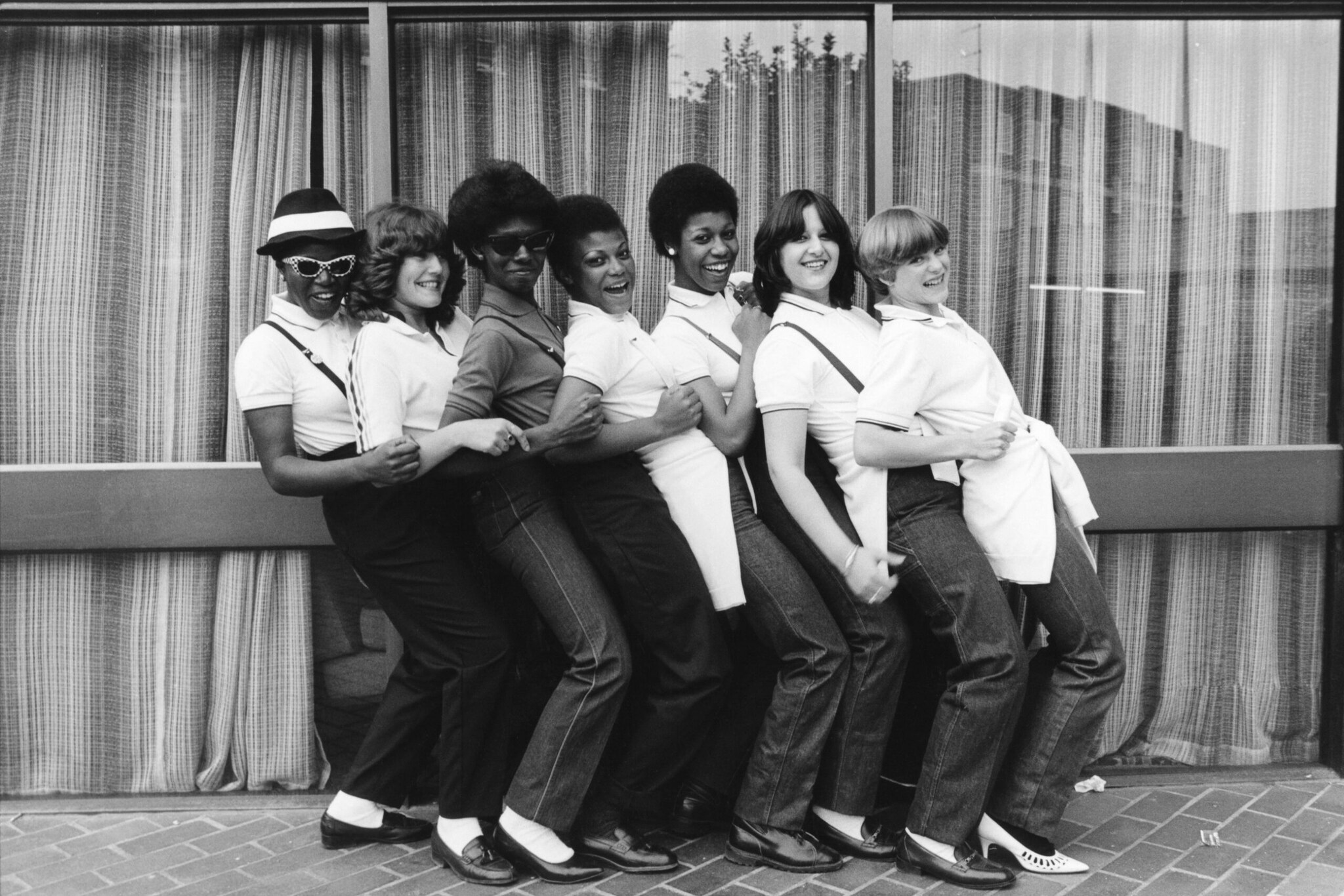 Schwarzweißaufnahme einer Gruppe junger Frauen in weißen Poloshirts