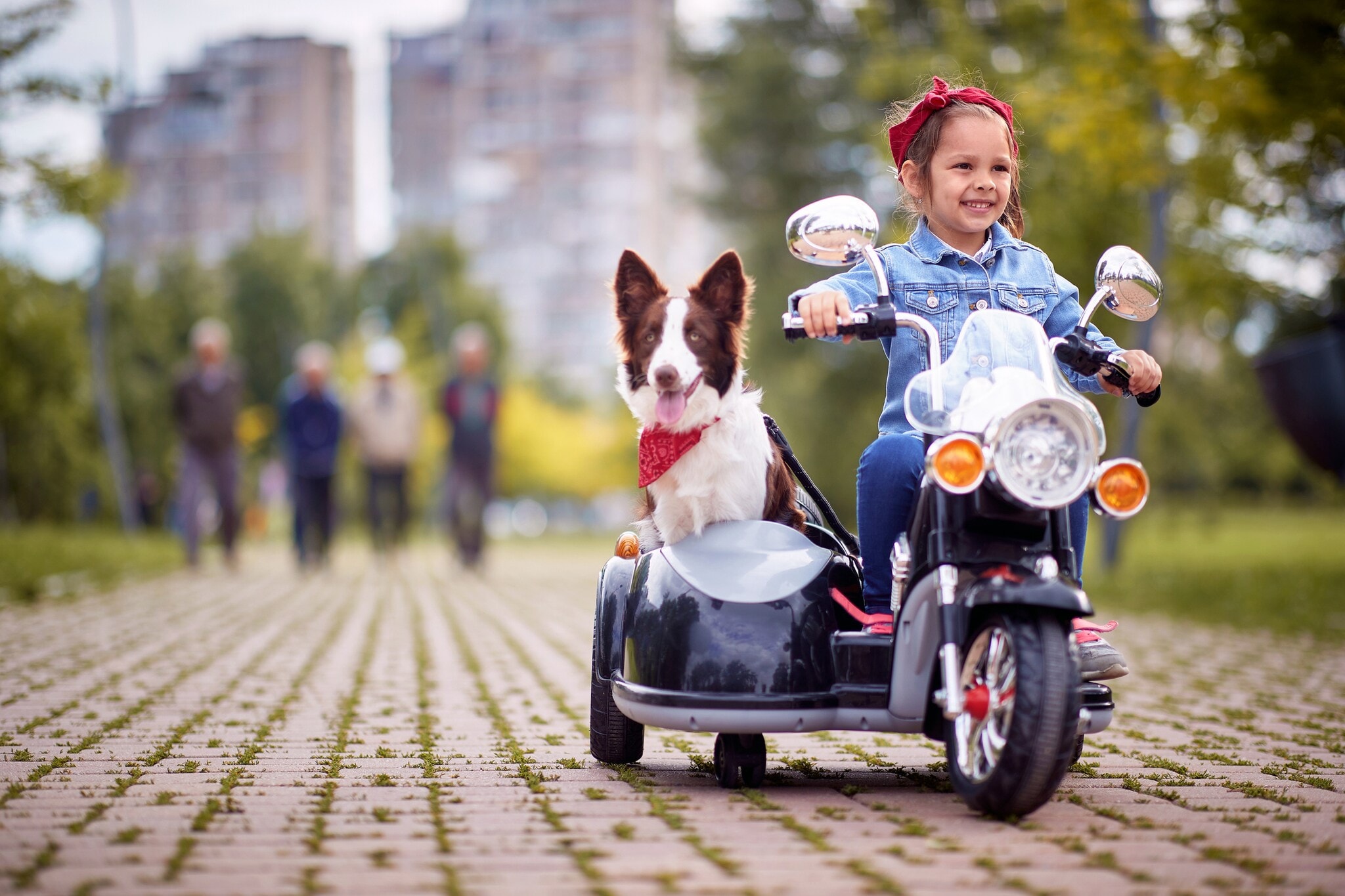 Kleines Mädchen mit Hund auf einem Kindermotorrad Kleines Mädchen mit Hund auf einem Kindermotorrad