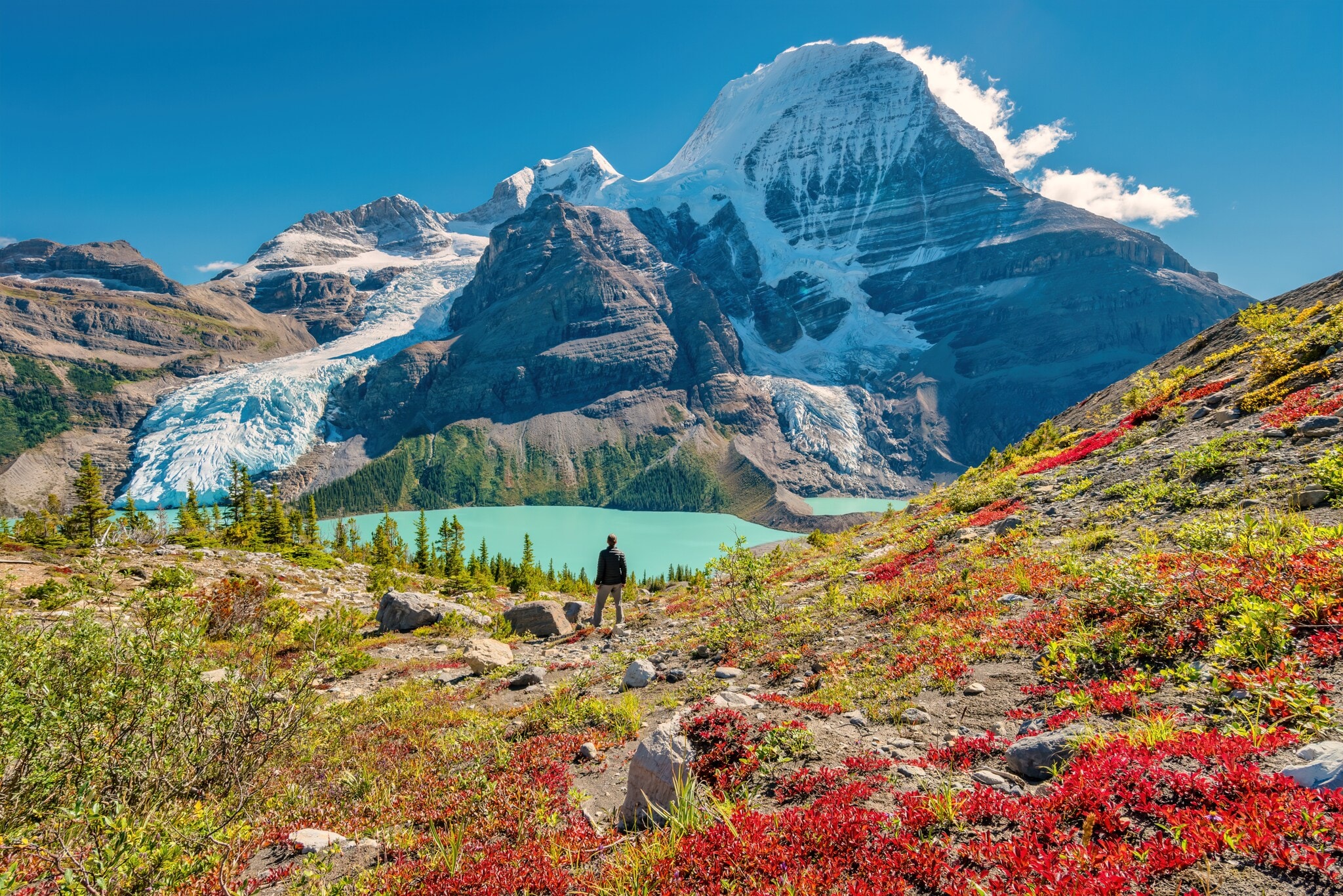 Ein Wanderer steht an einem See im Gebirge eines Nationalparks in Kanada Ein Wanderer steht an einem See im Gebirge eines Nationalparks in Kanada