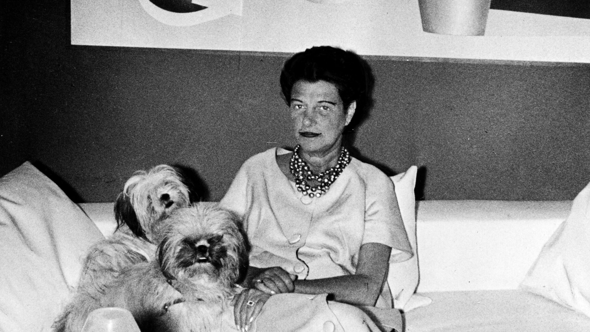 Porträt von Peggy Guggenheim auf einem Sofa mit zwei Hunden, Schwarzweißaufnahme