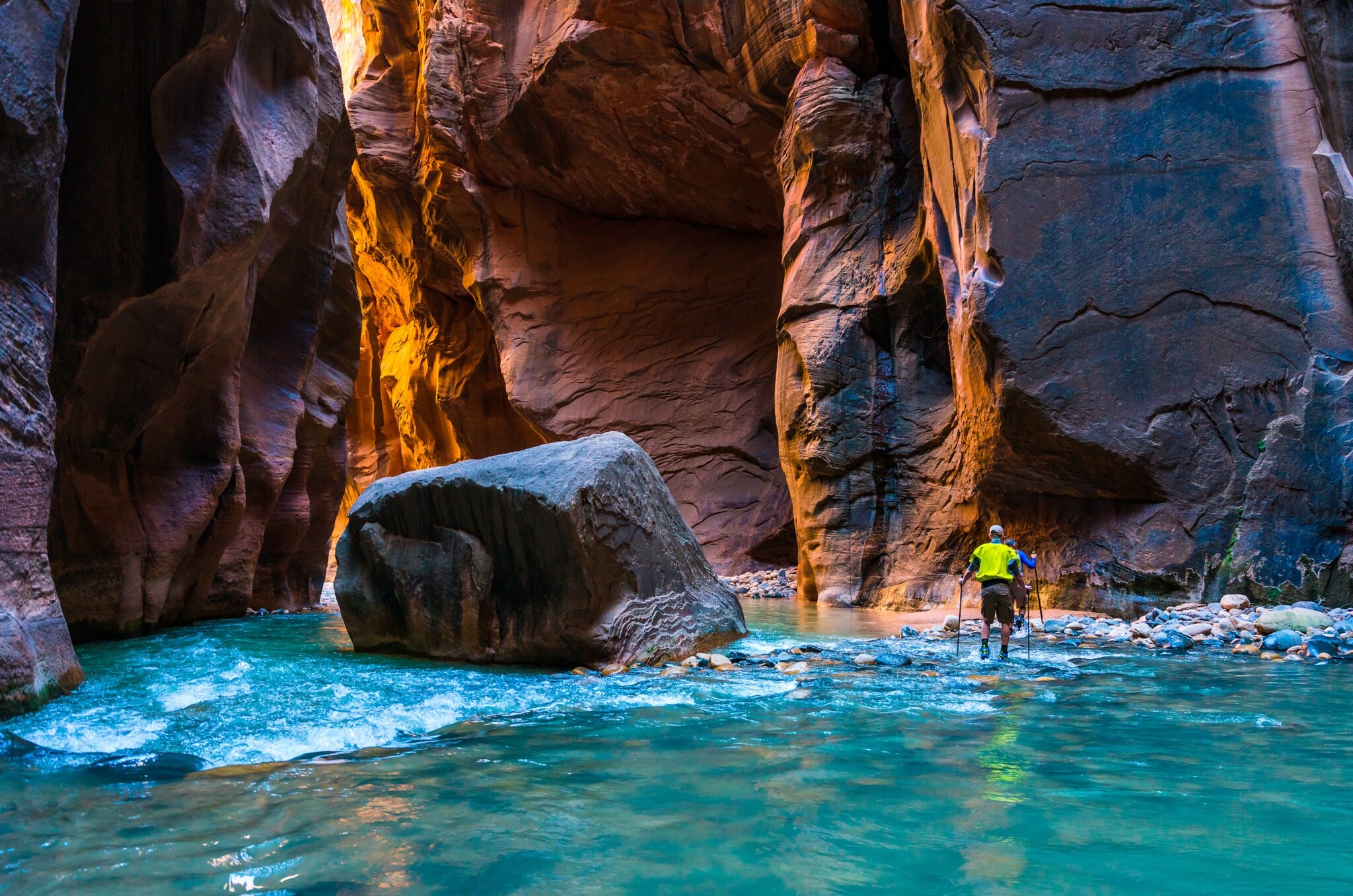 Zwei Wanderer waten durch einen Fluß zwischen Felswänden Zwei Wanderer waten durch einen Fluß zwischen Felswänden