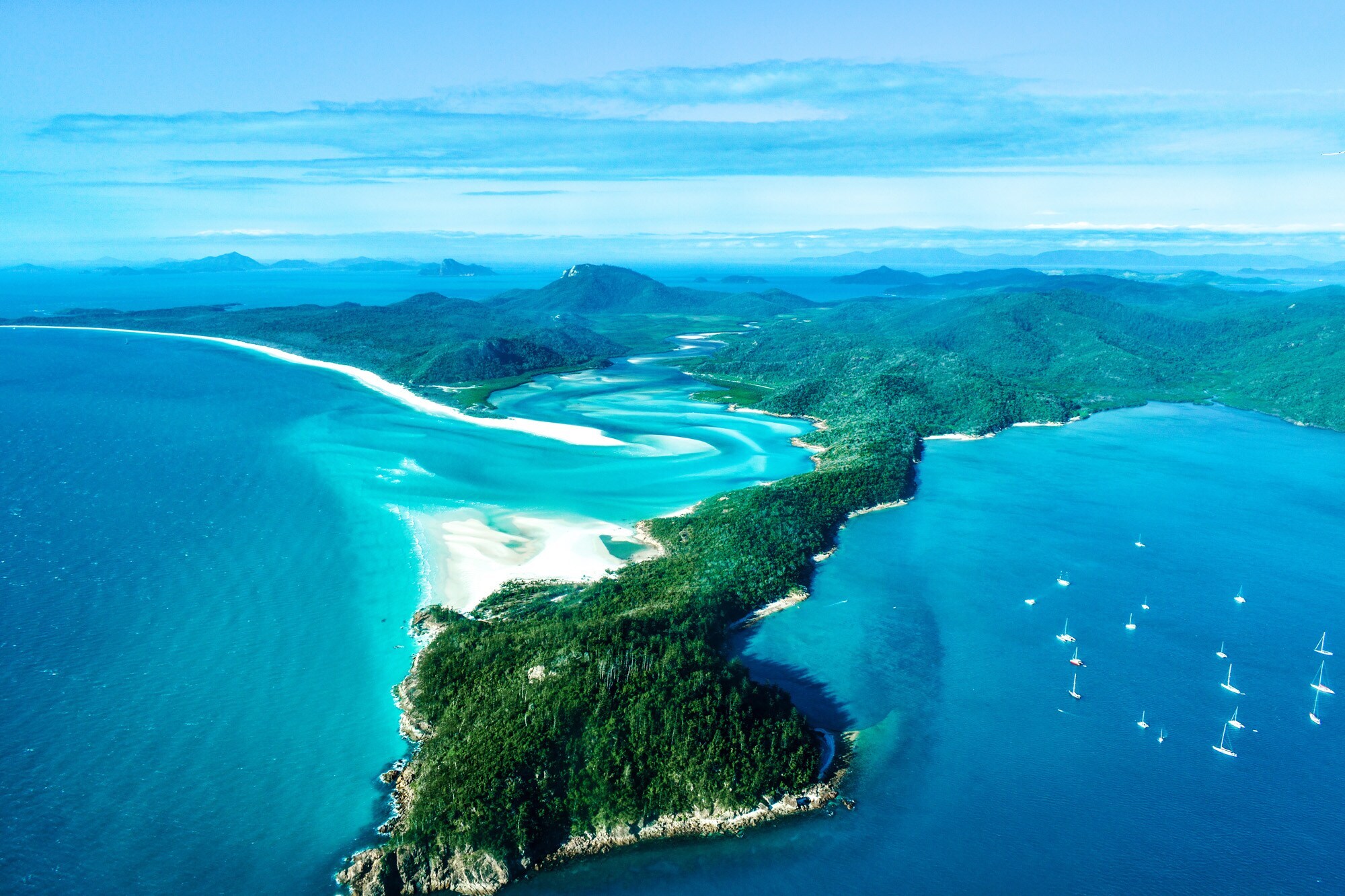 Tropische Inselgruppe mit Segelbooten im türkisblauen Wasser Tropische Inselgruppe mit Segelbooten im türkisblauen Wasser